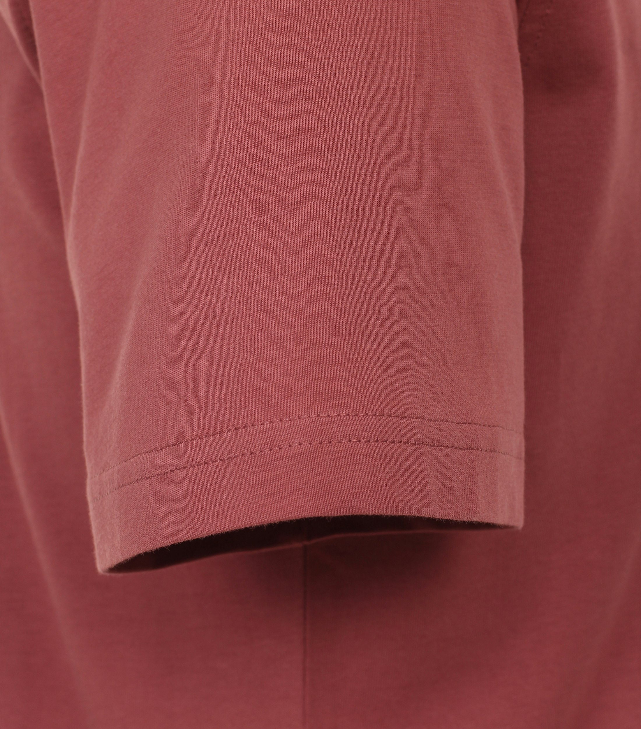 Das Model trägt ein TShirt im uni Muster in der Farbe Hellrot