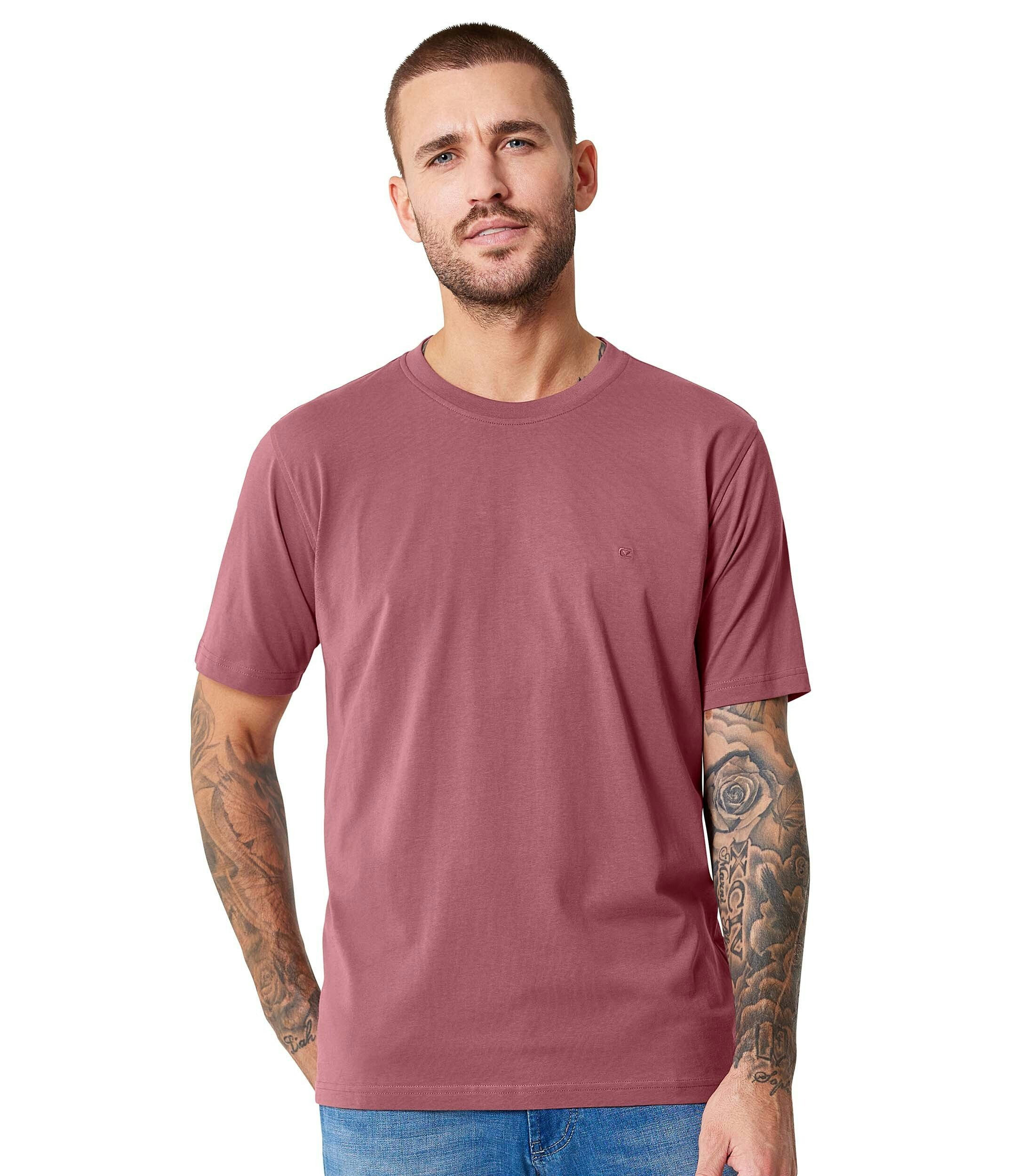 Das Model trägt ein TShirt im uni Muster in der Farbe Hellrot