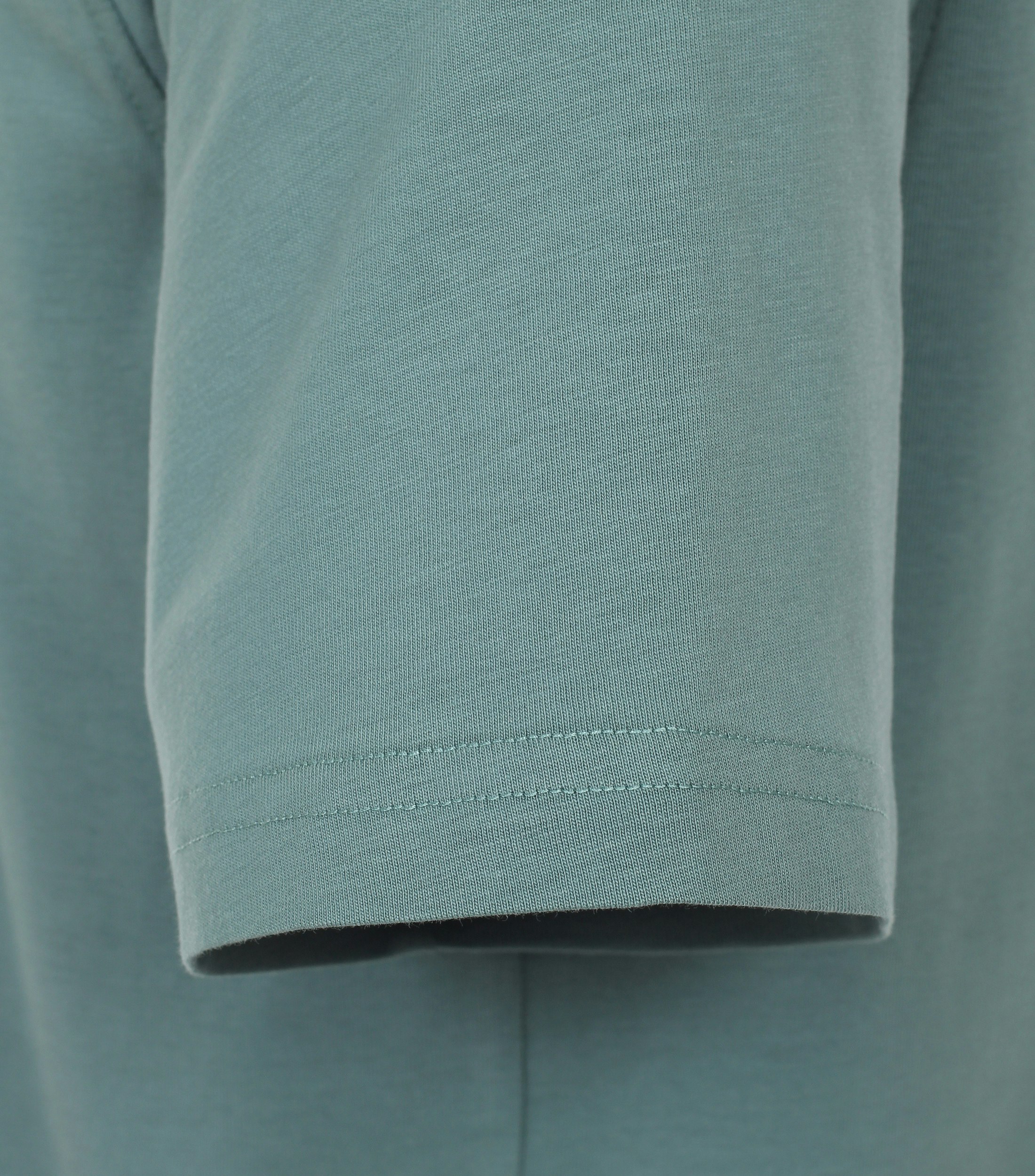 Das Model trägt ein TShirt im uni Muster in der Farbe Türkisgrün