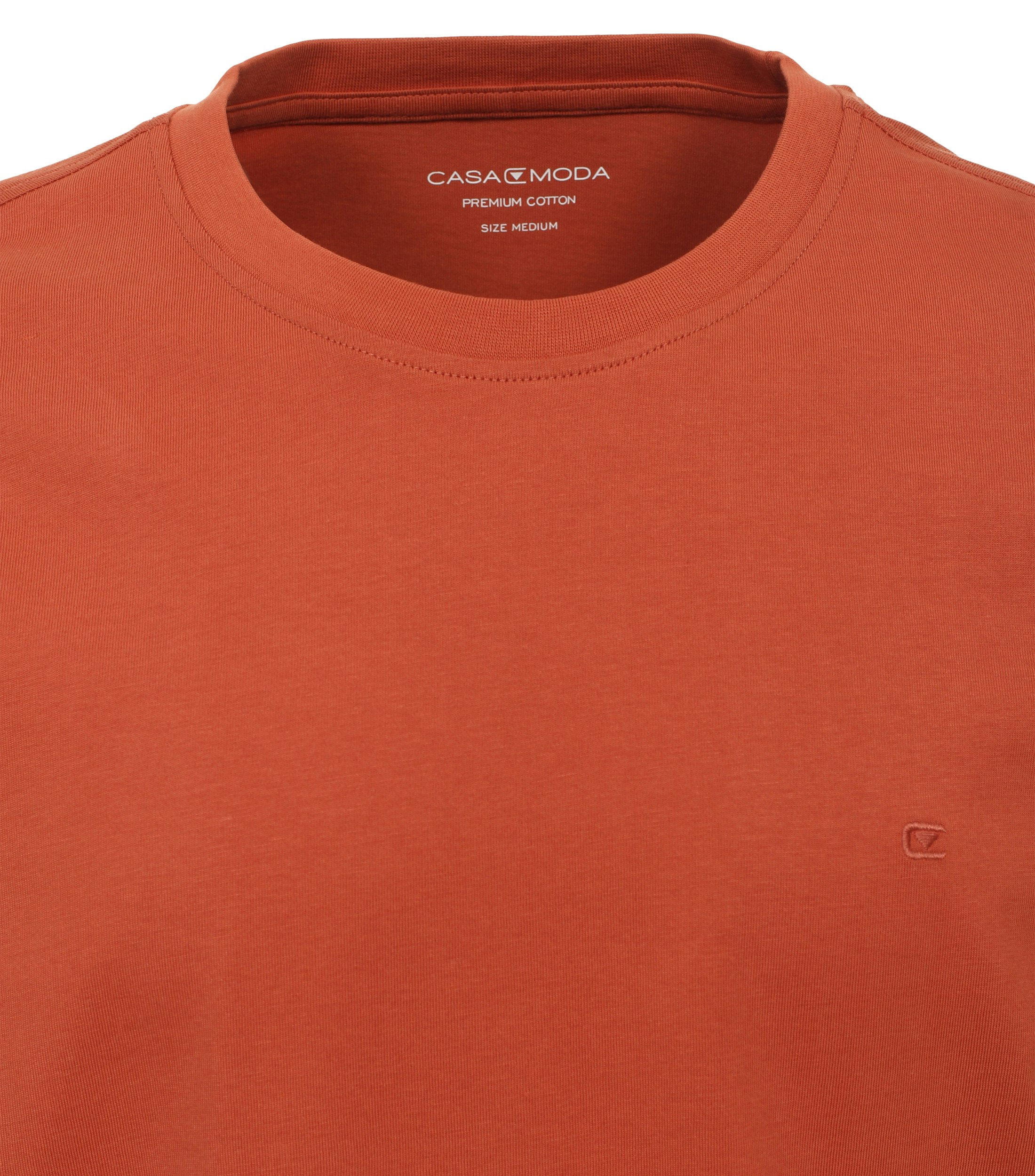 Das Model trägt ein TShirt im uni Muster in der Farbe Dunkelorange