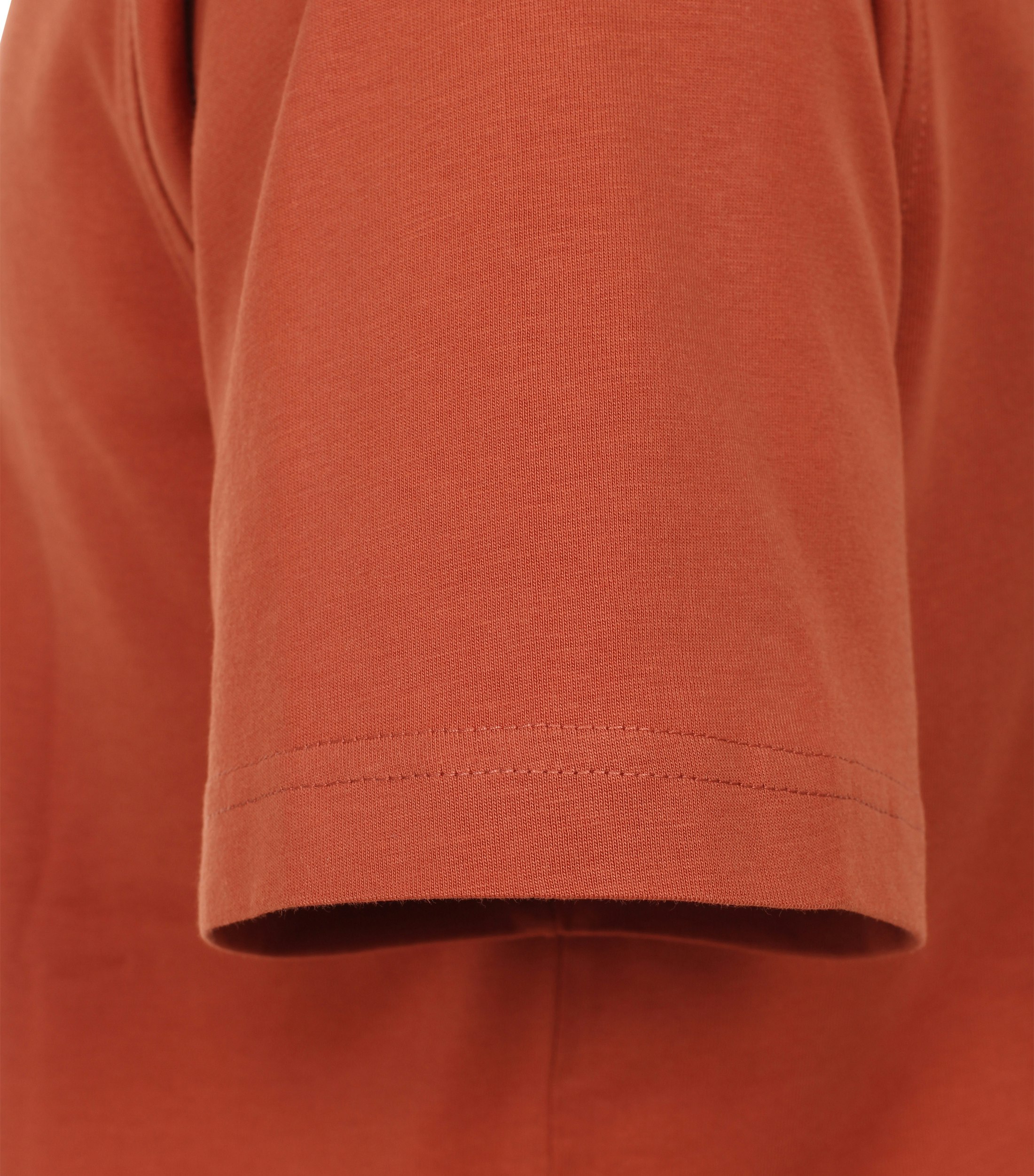 Das Model trägt ein TShirt im uni Muster in der Farbe Dunkelorange