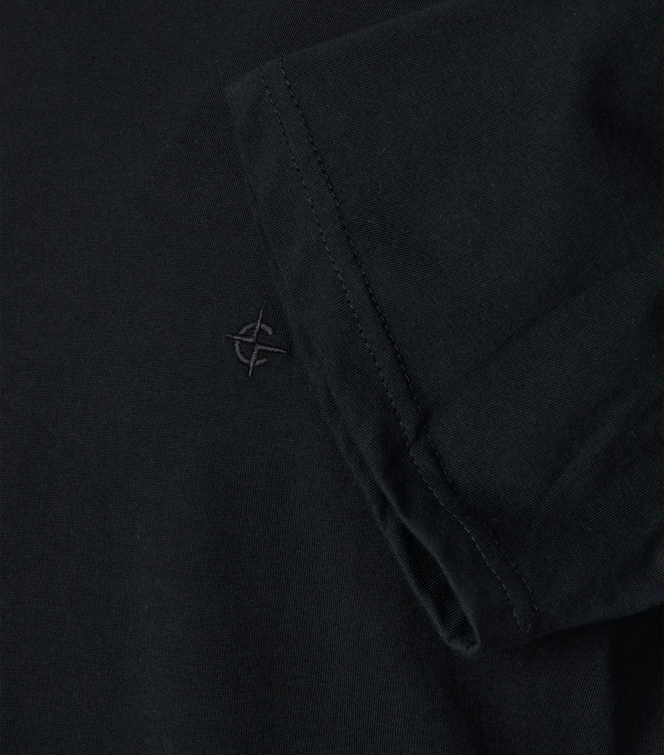 Das Model trägt ein TShirt im uni Muster in der Farbe Schwarz