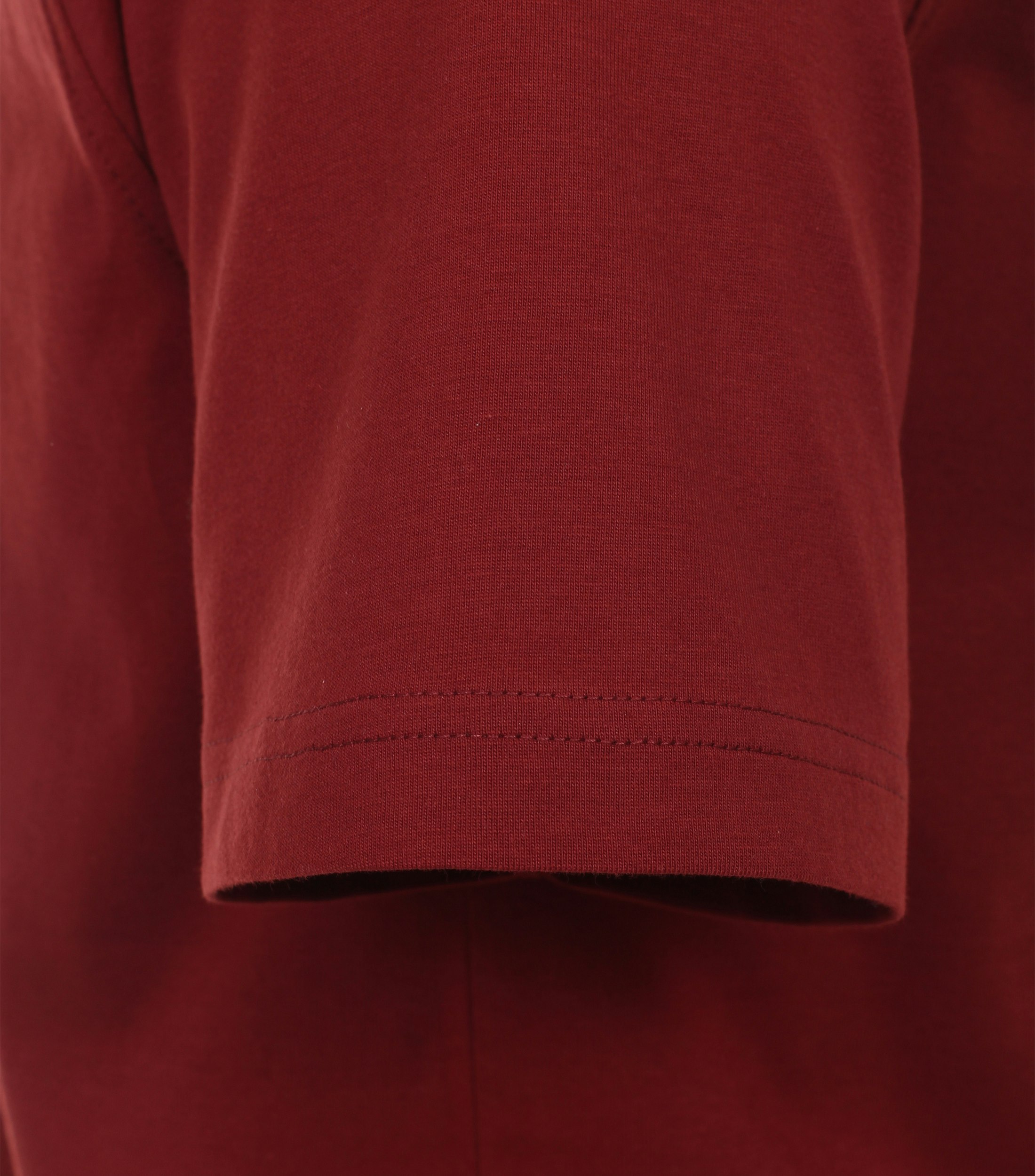 Das Model trägt ein TShirt im uni Muster in der Farbe Rot