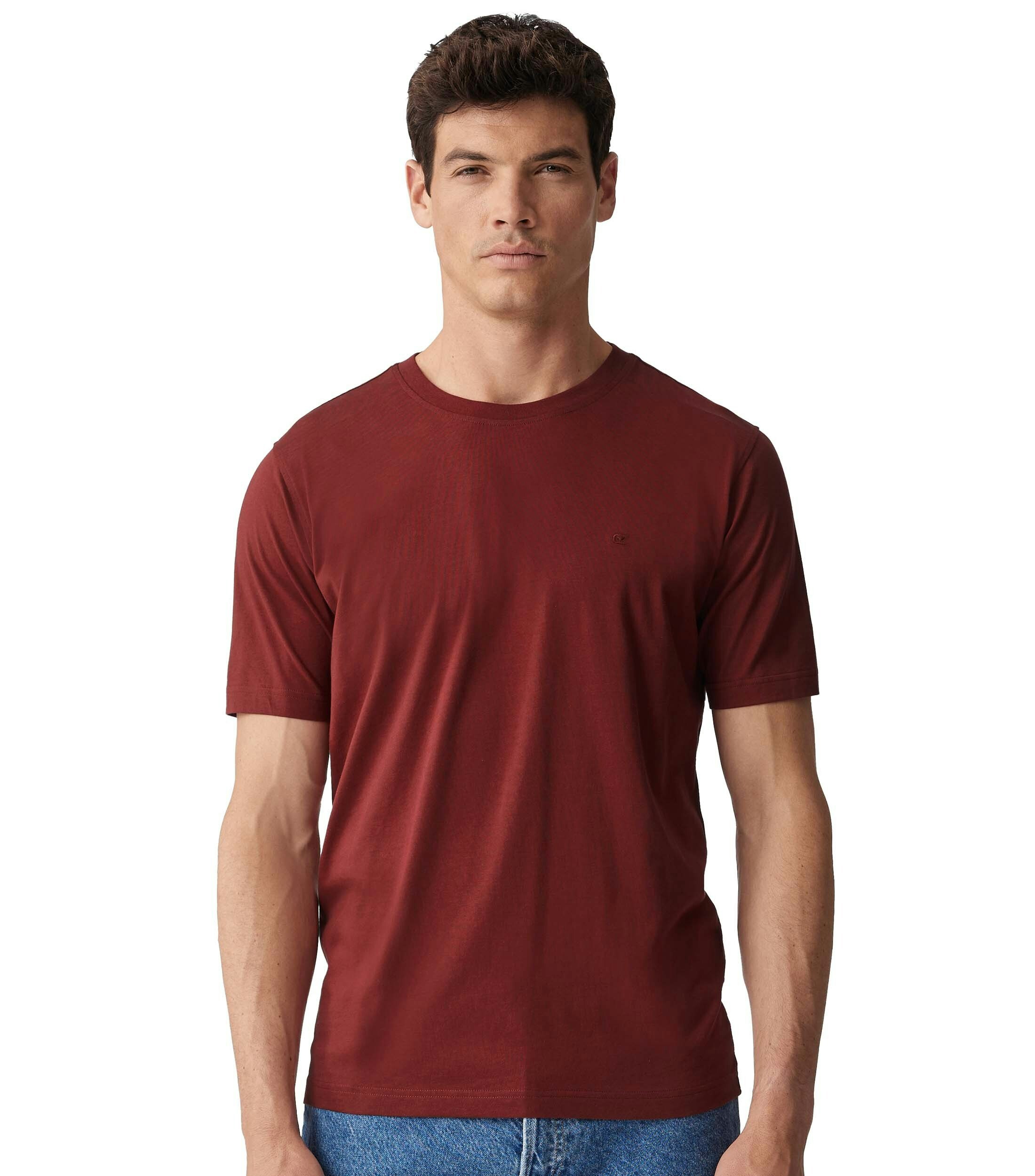 Das Model trägt ein TShirt im uni Muster in der Farbe Rot