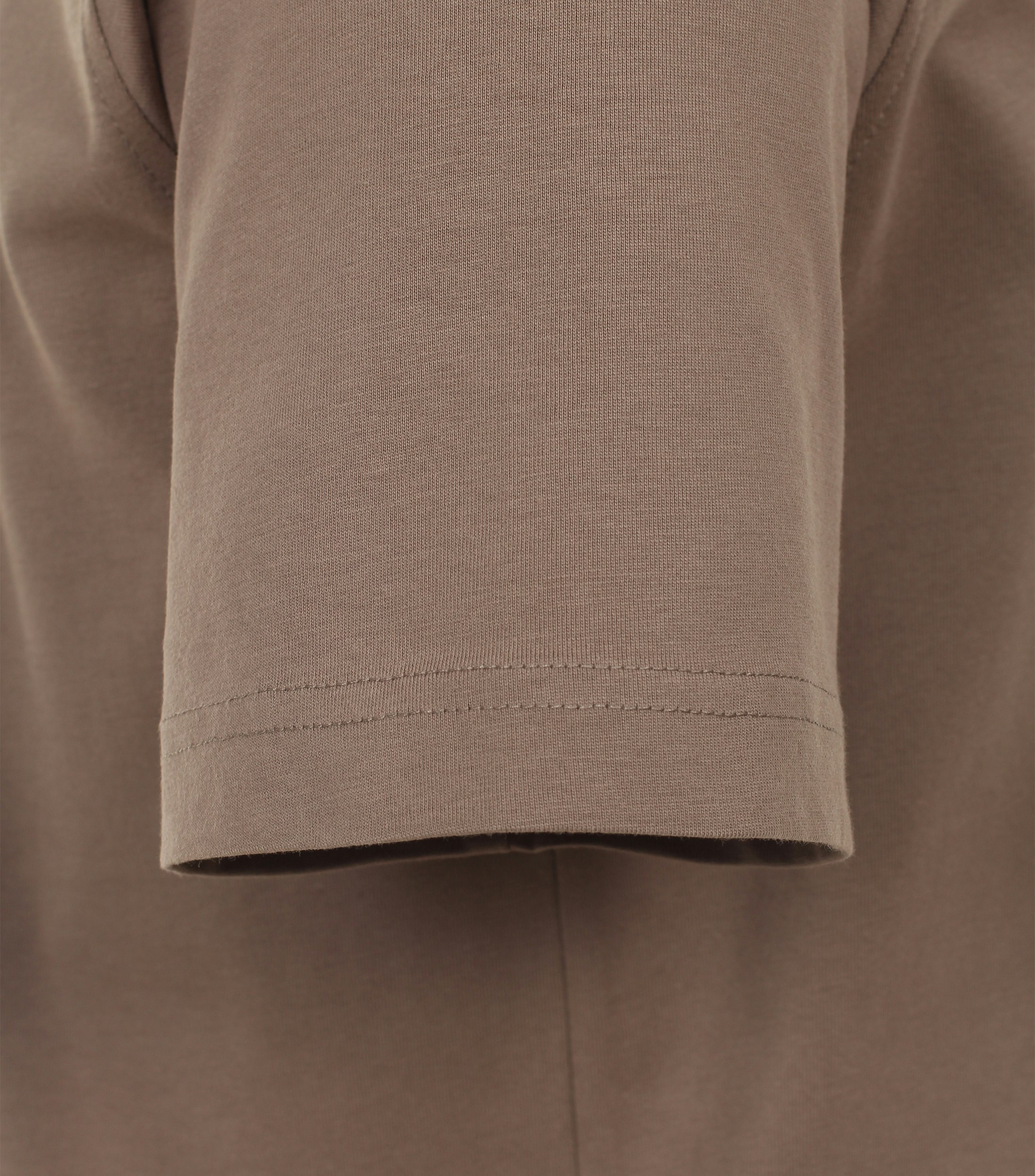 Das Model trägt ein TShirt im uni Muster in der Farbe Beige