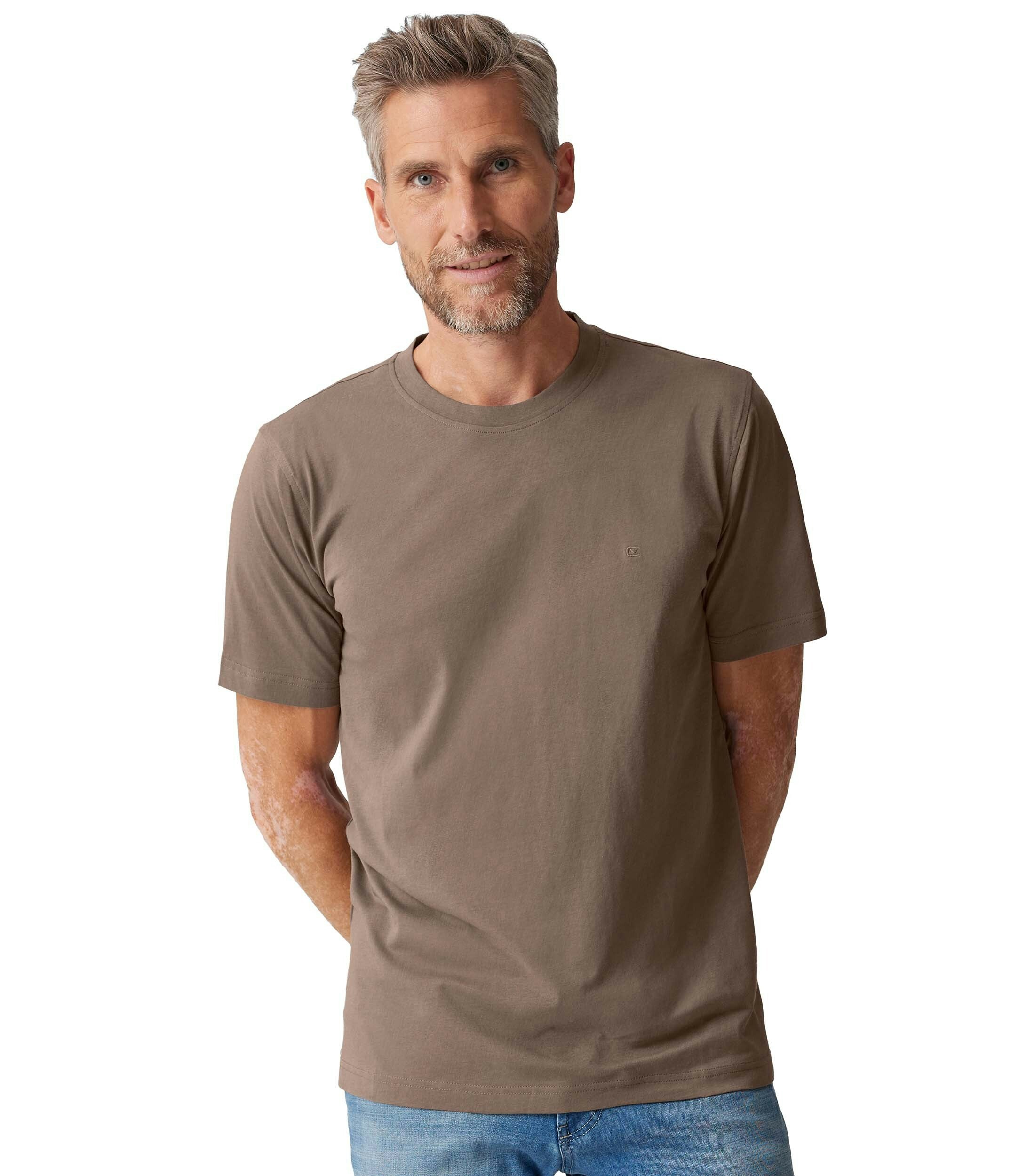 Das Model trägt ein TShirt im uni Muster in der Farbe Beige