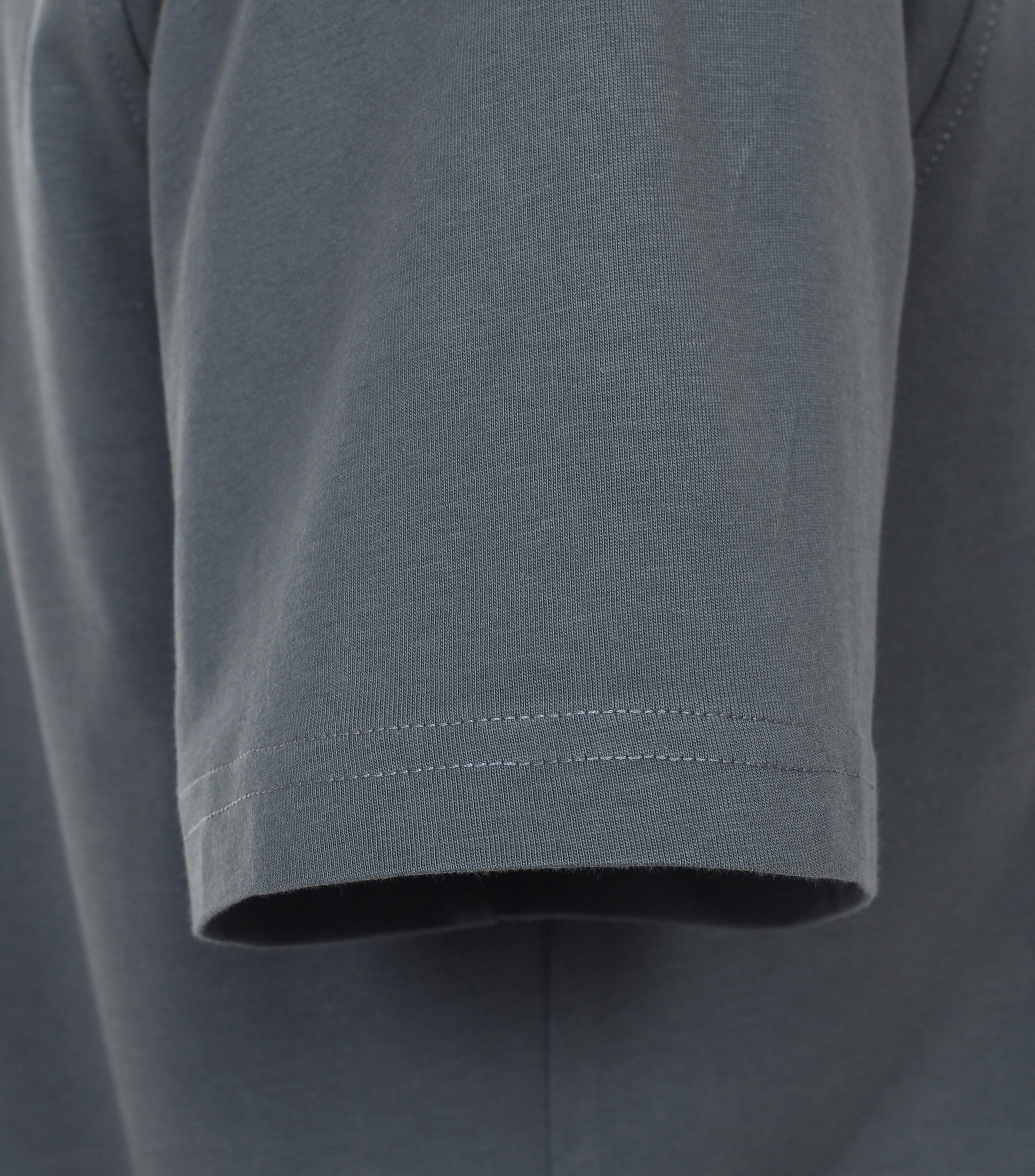 Das Model trägt ein TShirt im uni Muster in der Farbe Dunkelgrau