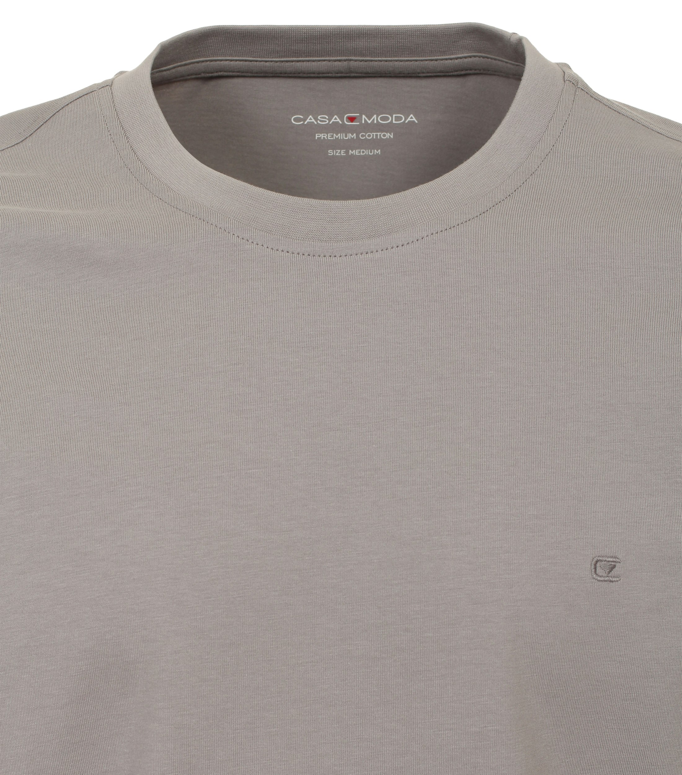 Das Model trägt ein TShirt im uni Muster in der Farbe Hellgrau
