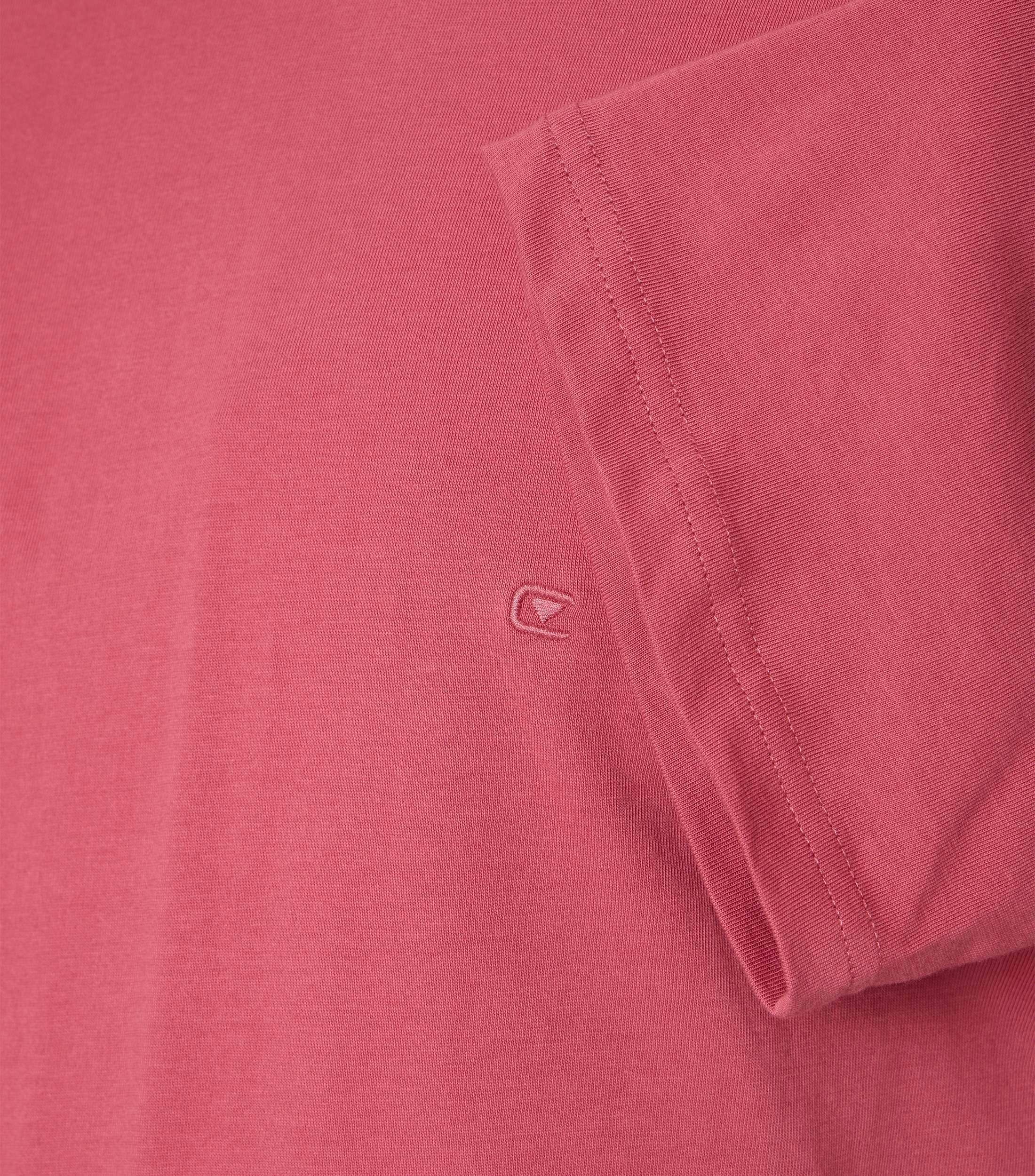 Das Model trägt ein TShirt im uni Muster in der Farbe Hellrot