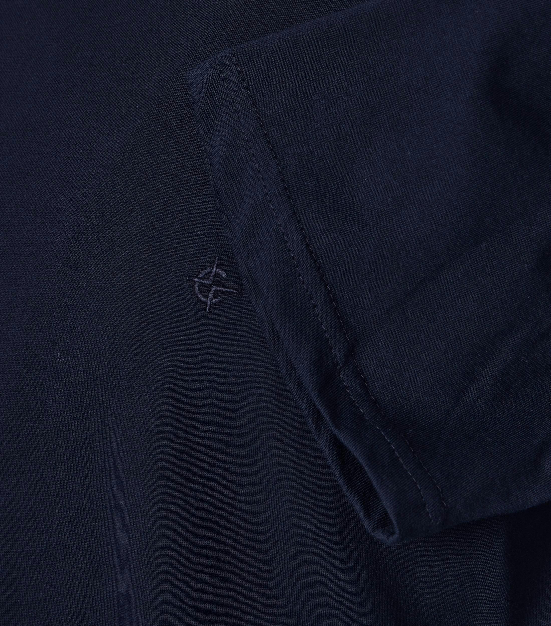 Das Model trägt ein TShirt im uni Muster in der Farbe Dunkelblau