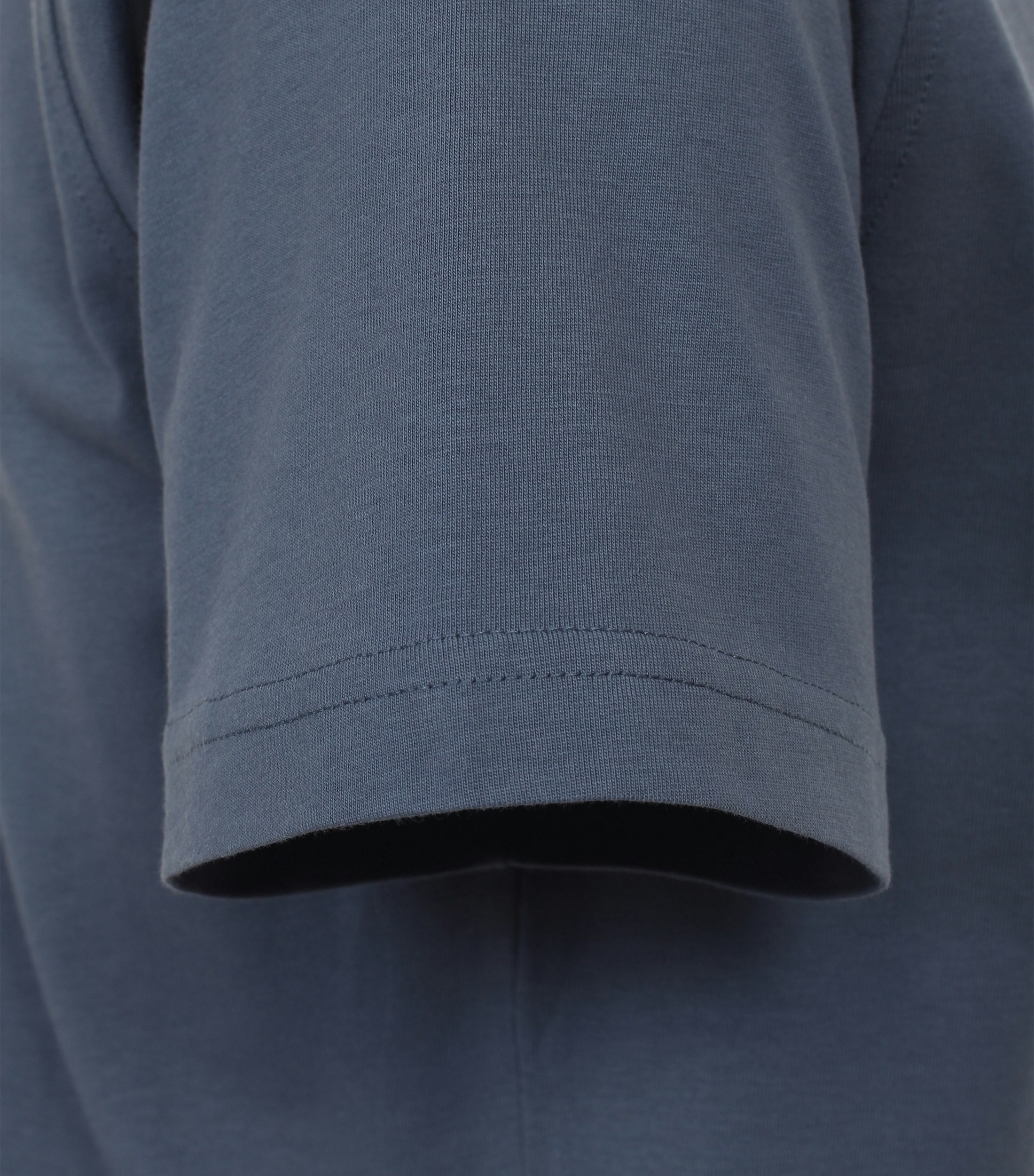 Das Model trägt ein TShirt im uni Muster in der Farbe Aquadunkelblau