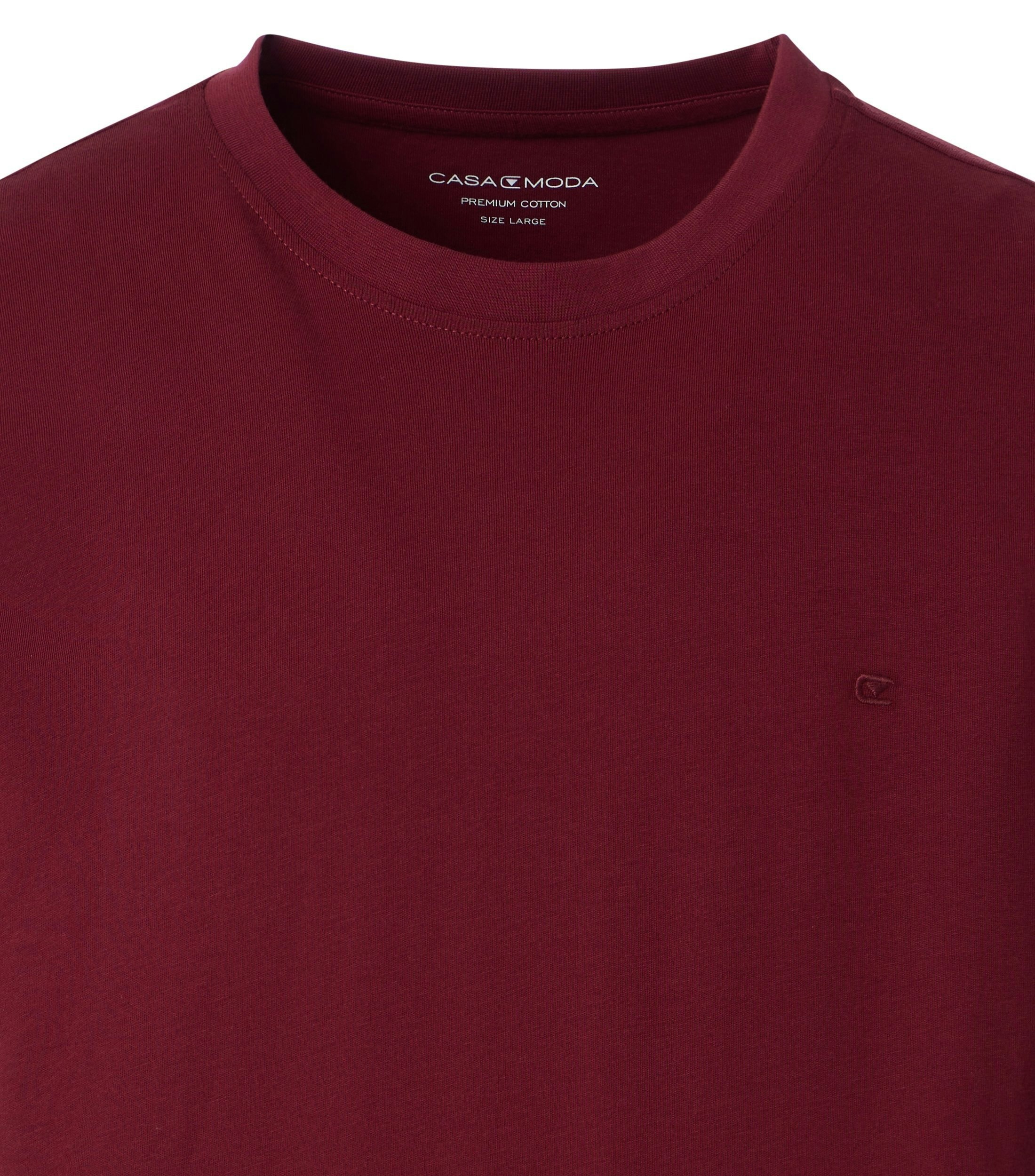 Das Model trägt ein TShirt im uni Muster in der Farbe Bordeauxrot
