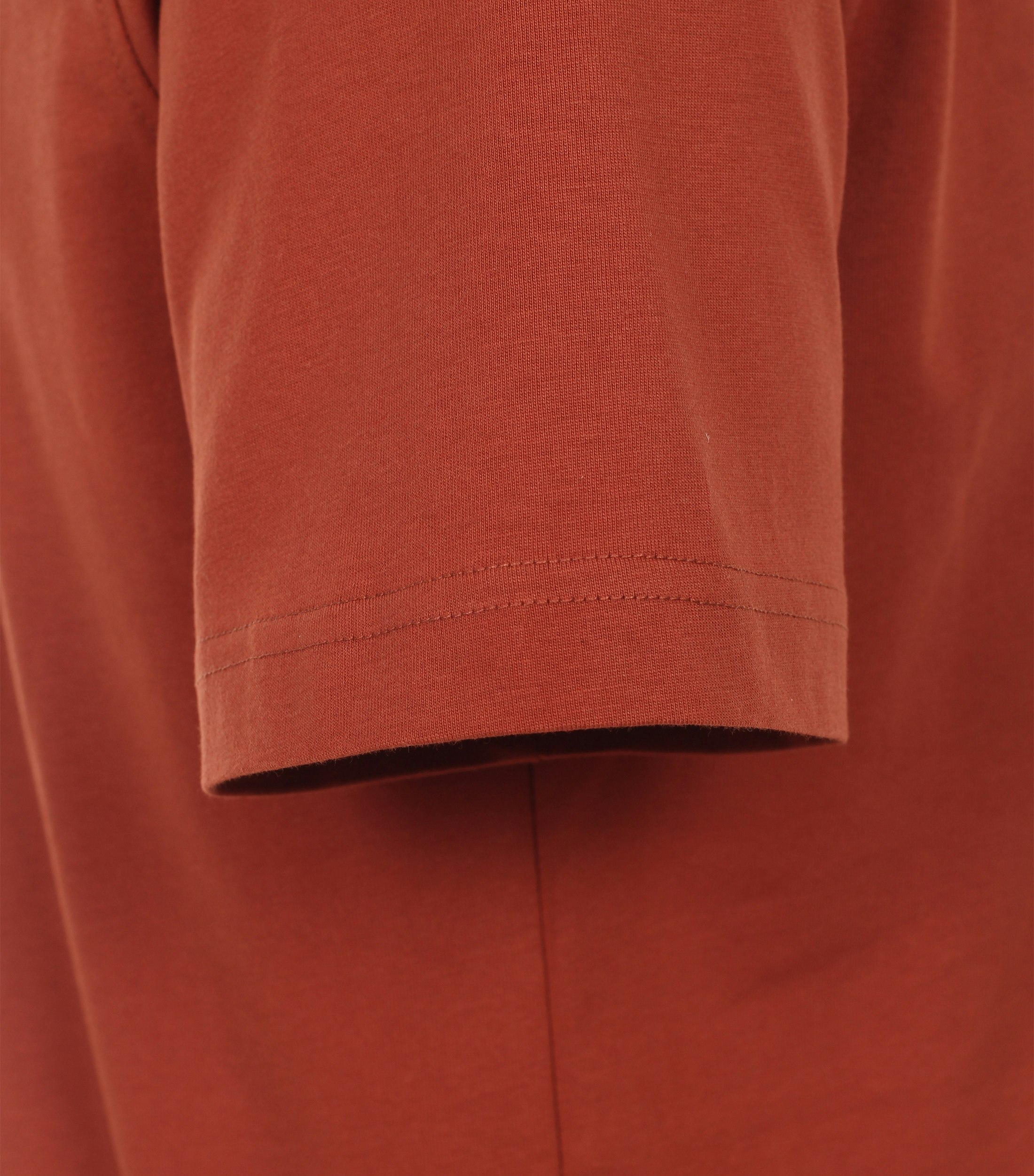 Das Model trägt ein TShirt im uni Muster in der Farbe Orange