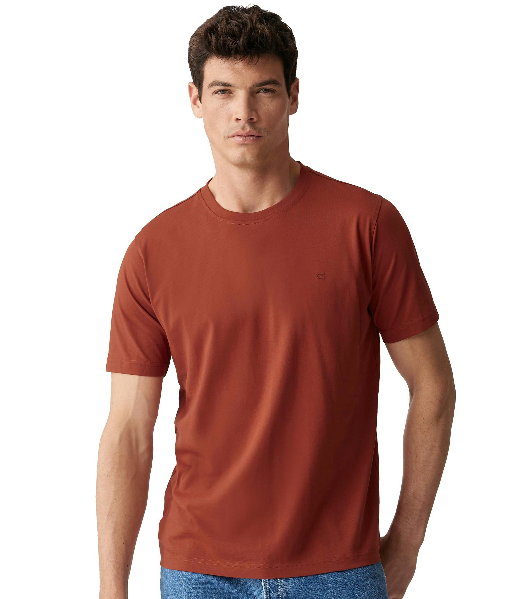 Das Model trägt ein TShirt im uni Muster in der Farbe Orange