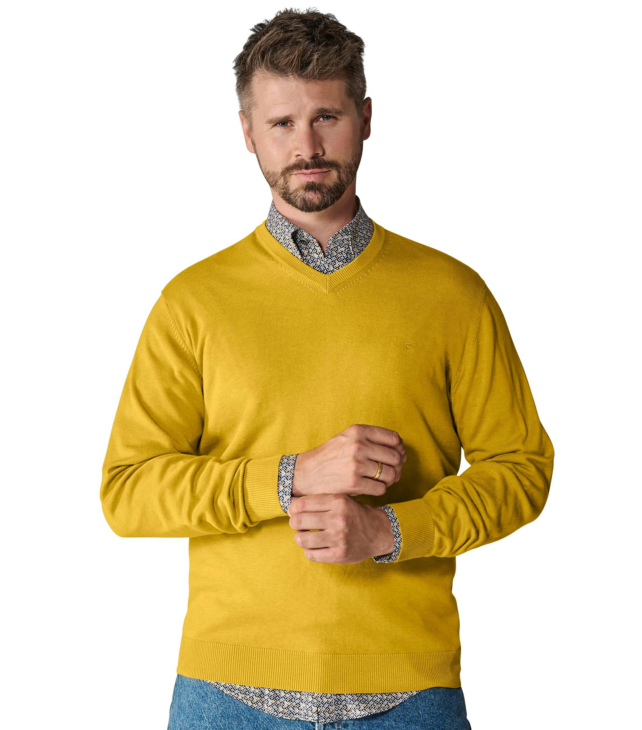 Das Model trägt ein Pullover im uni Muster in der Farbe Senfgelb