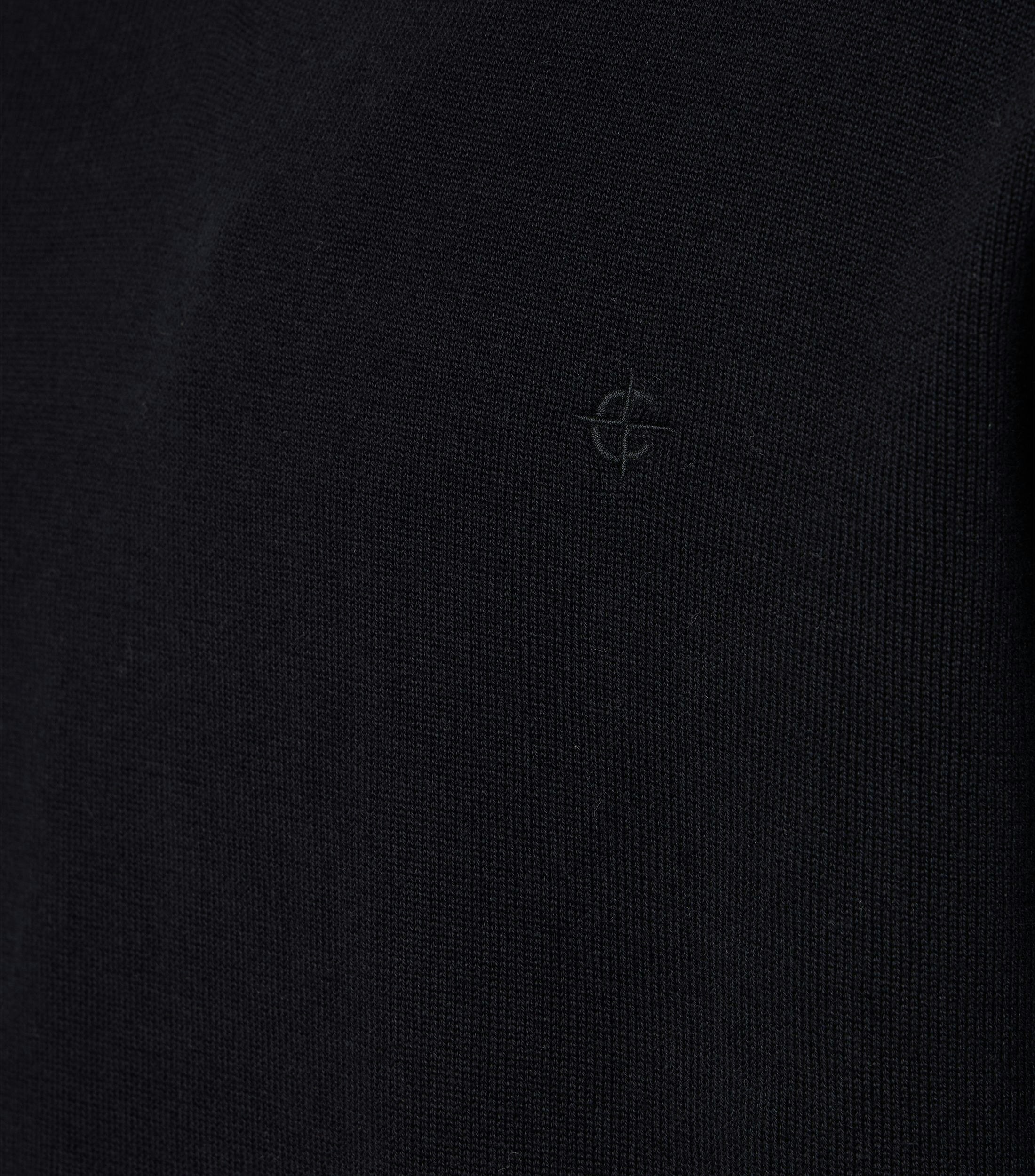 Das Model trägt ein Pullover im uni Muster in der Farbe Schwarz