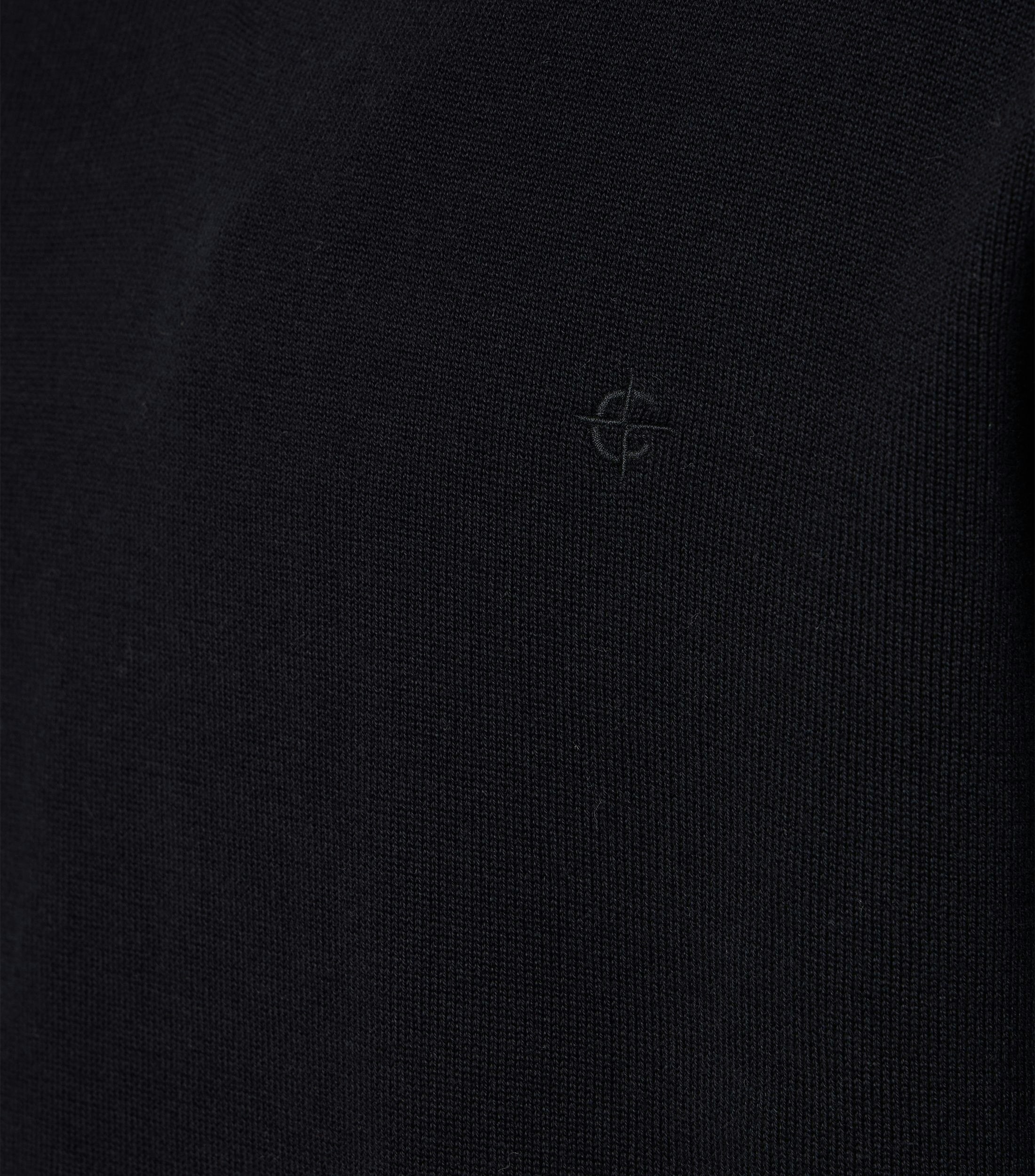 Das Model trägt ein Pullover im uni Muster in der Farbe Schwarz