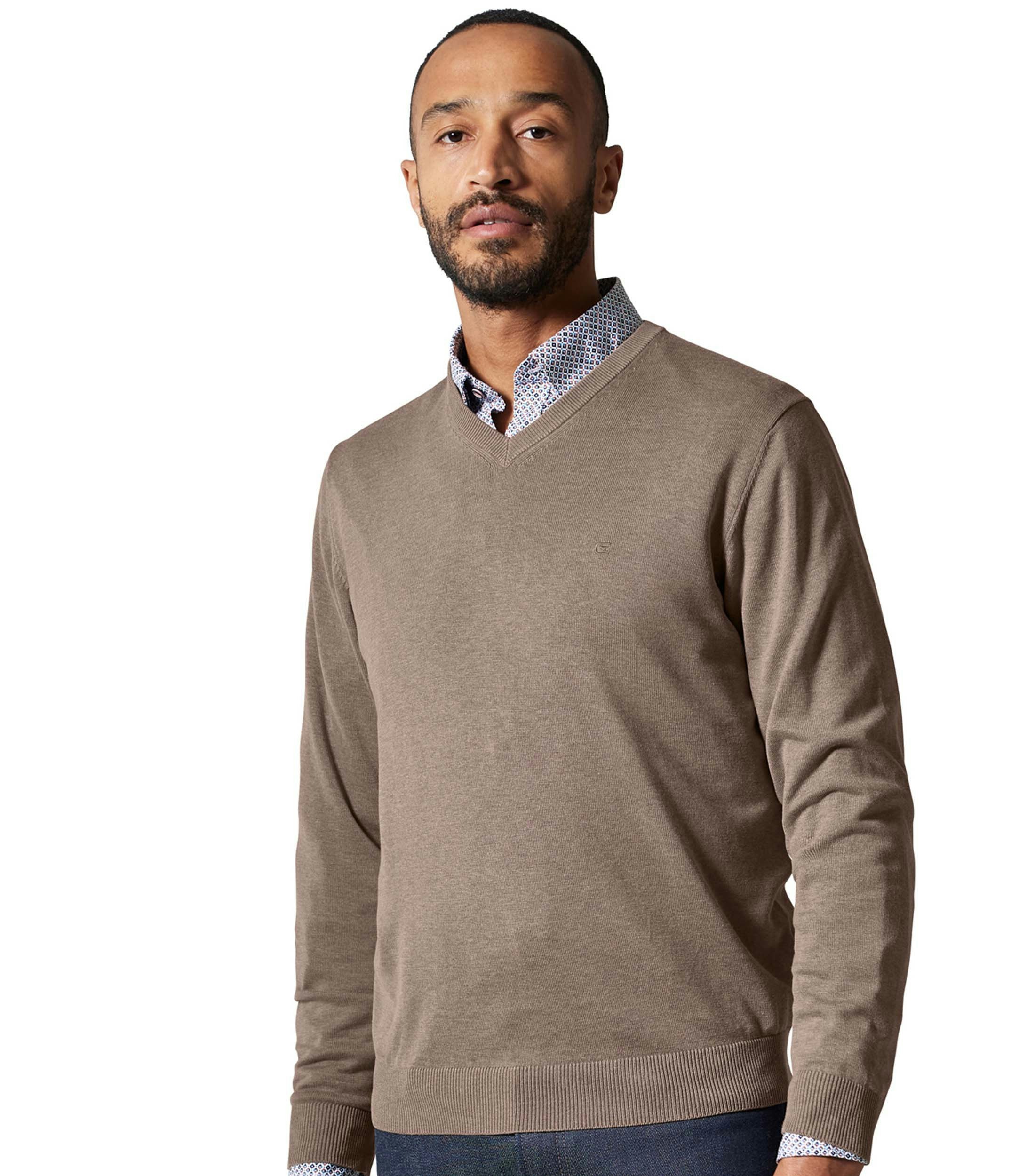 Das Model trägt ein Pullover im uni Muster in der Farbe Hellbraun