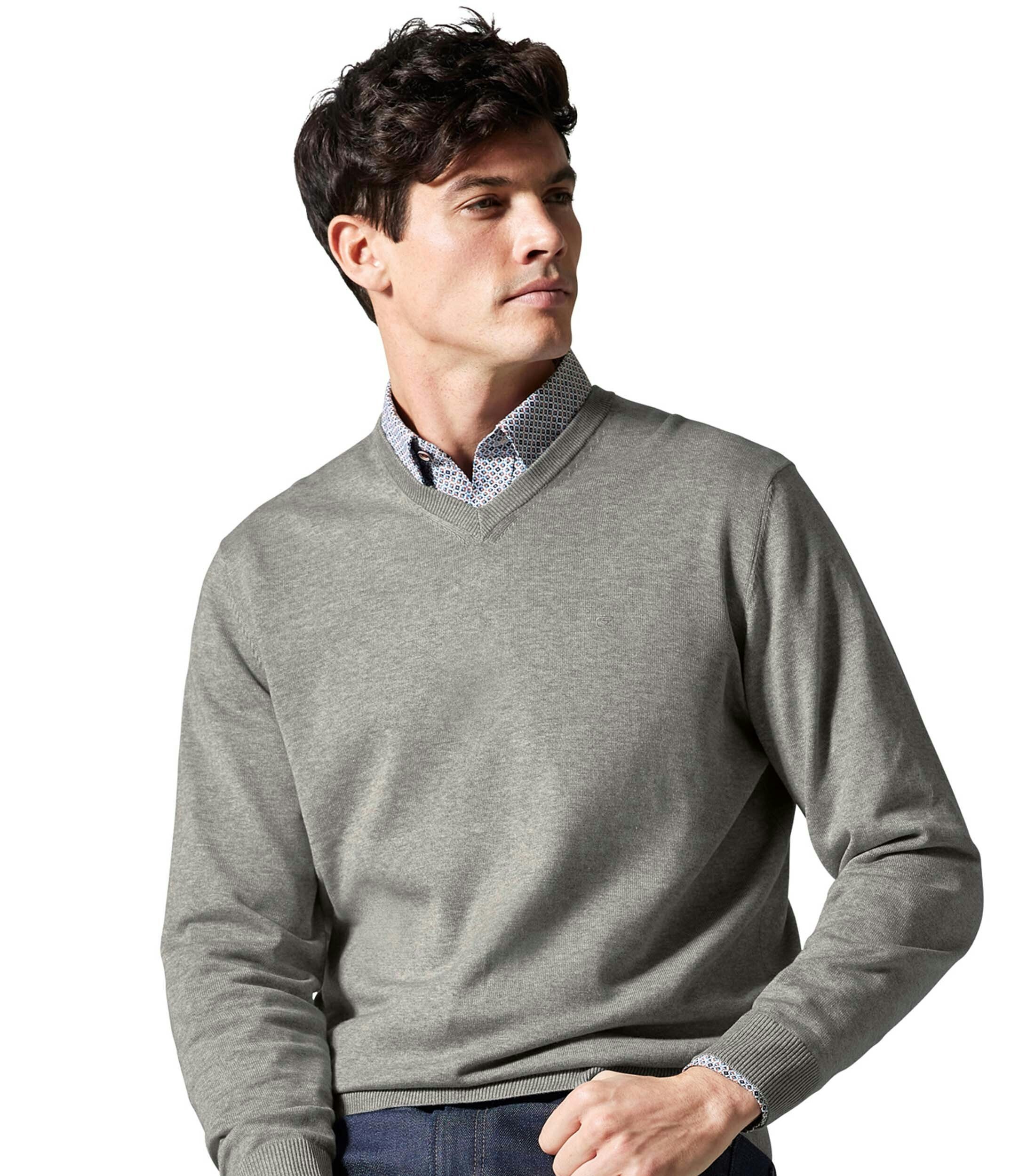 Das Model trägt ein Pullover im uni Muster in der Farbe Hellgrau