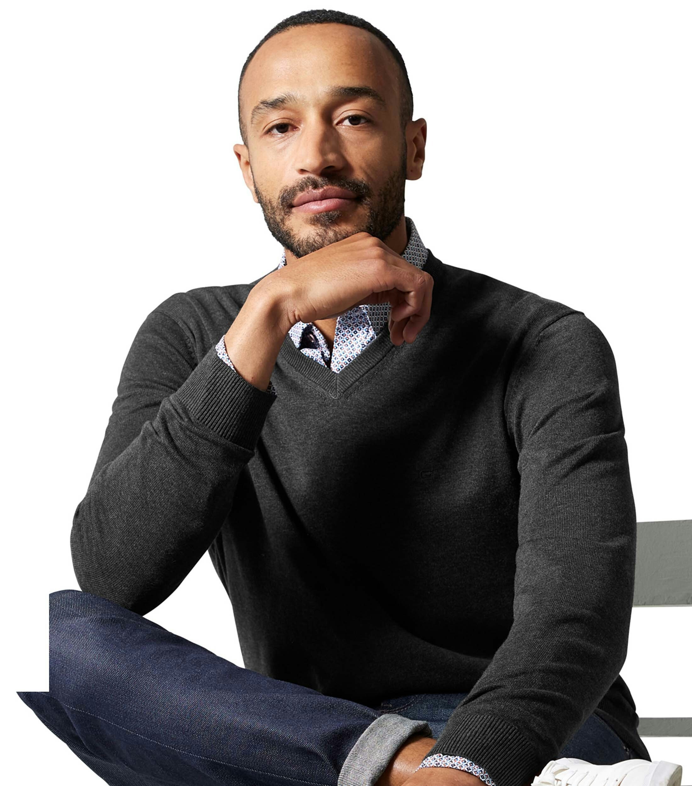 Das Model trägt ein Pullover im uni Muster in der Farbe Grauschwarz