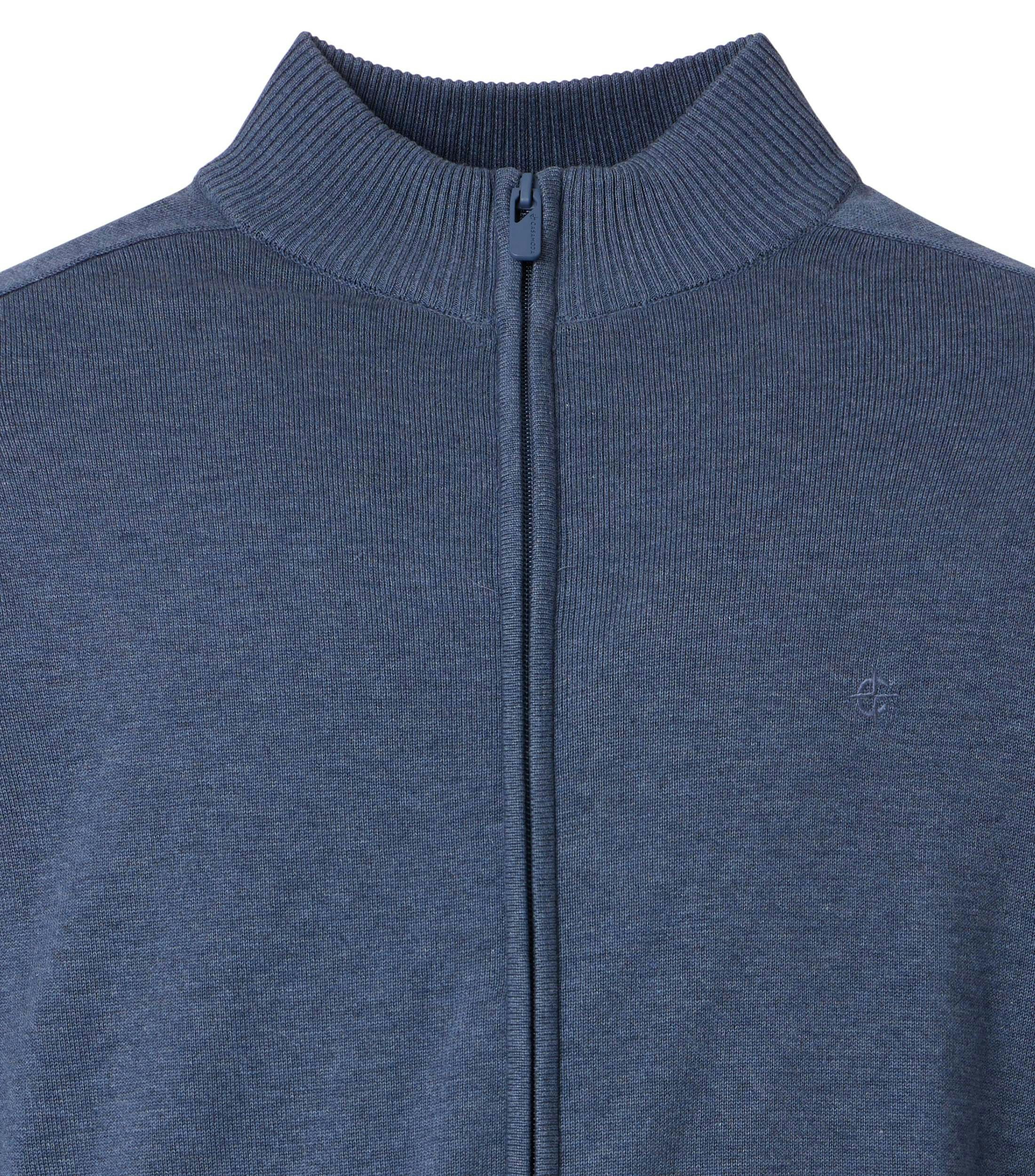 Das Model trägt eine Strickjacke im uni Muster in der Farbe dunkles Mittelblau