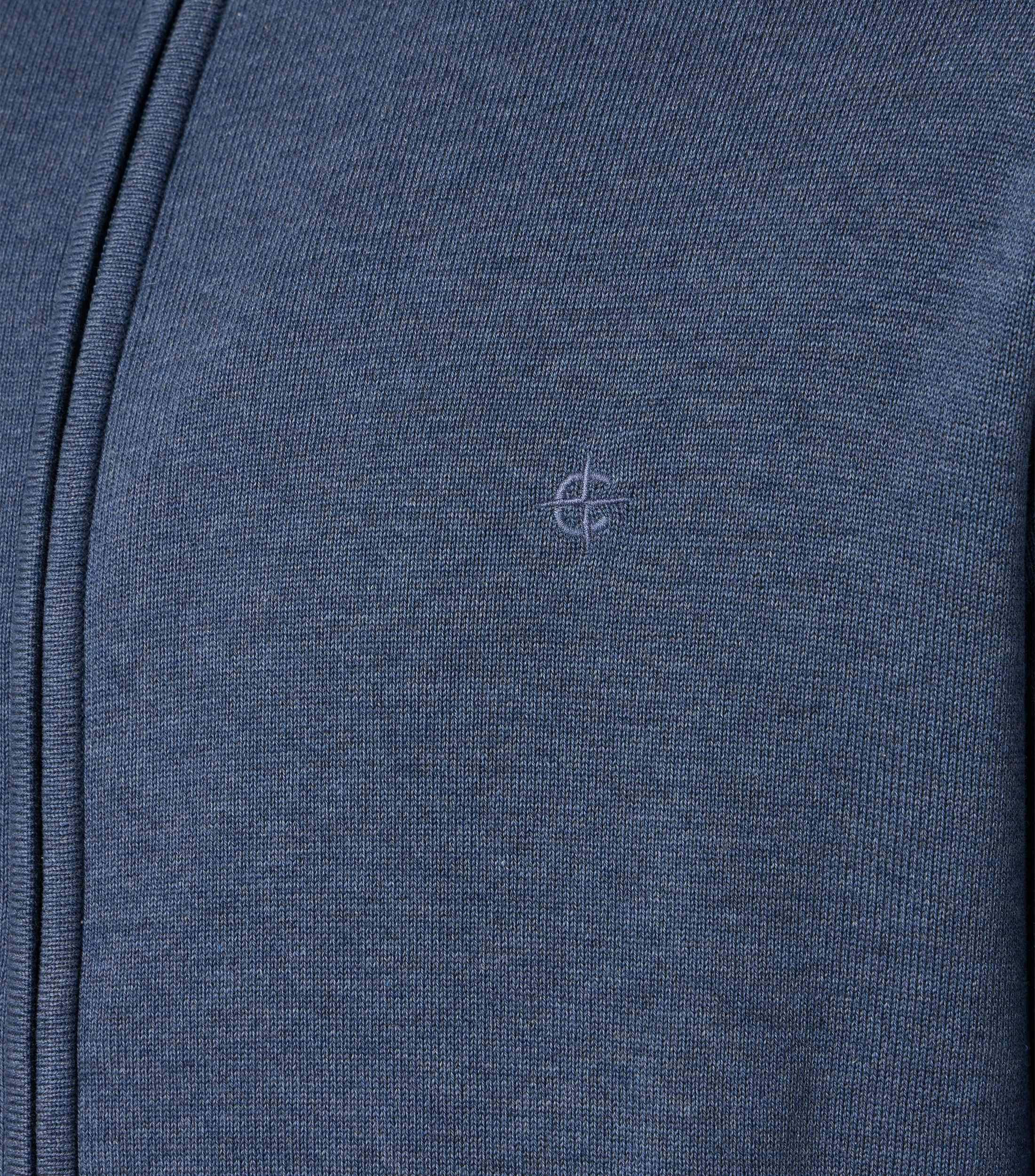 Das Model trägt eine Strickjacke im uni Muster in der Farbe dunkles Mittelblau