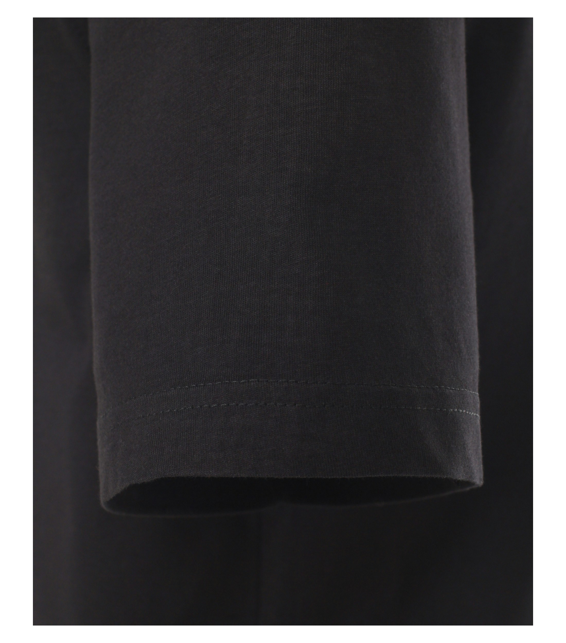 Das Model trägt ein TShirt im uni Muster in der Farbe Schwarz