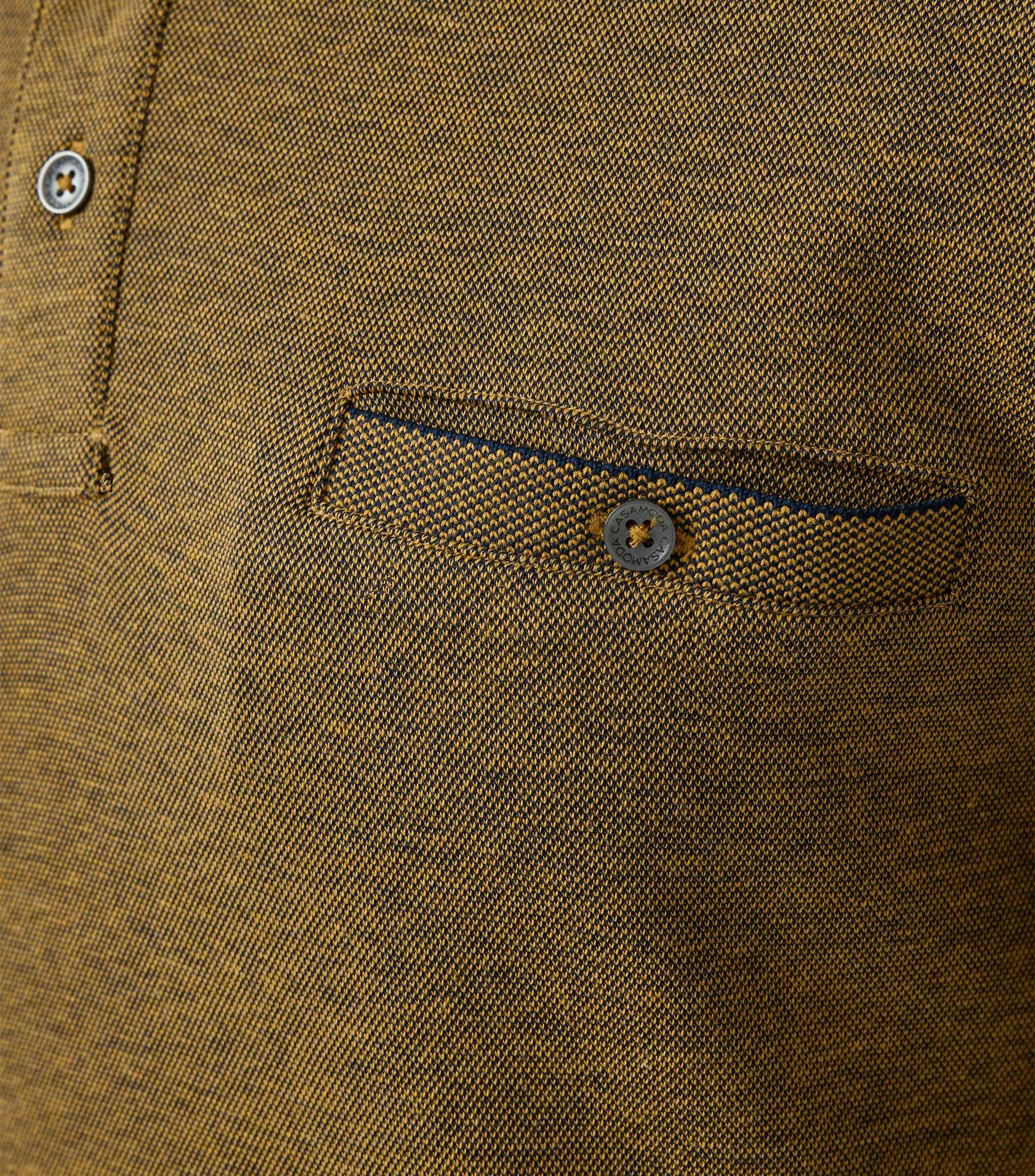 Das Model trägt ein PoloShirt im gestreift Muster in der Farbe Senfgelb