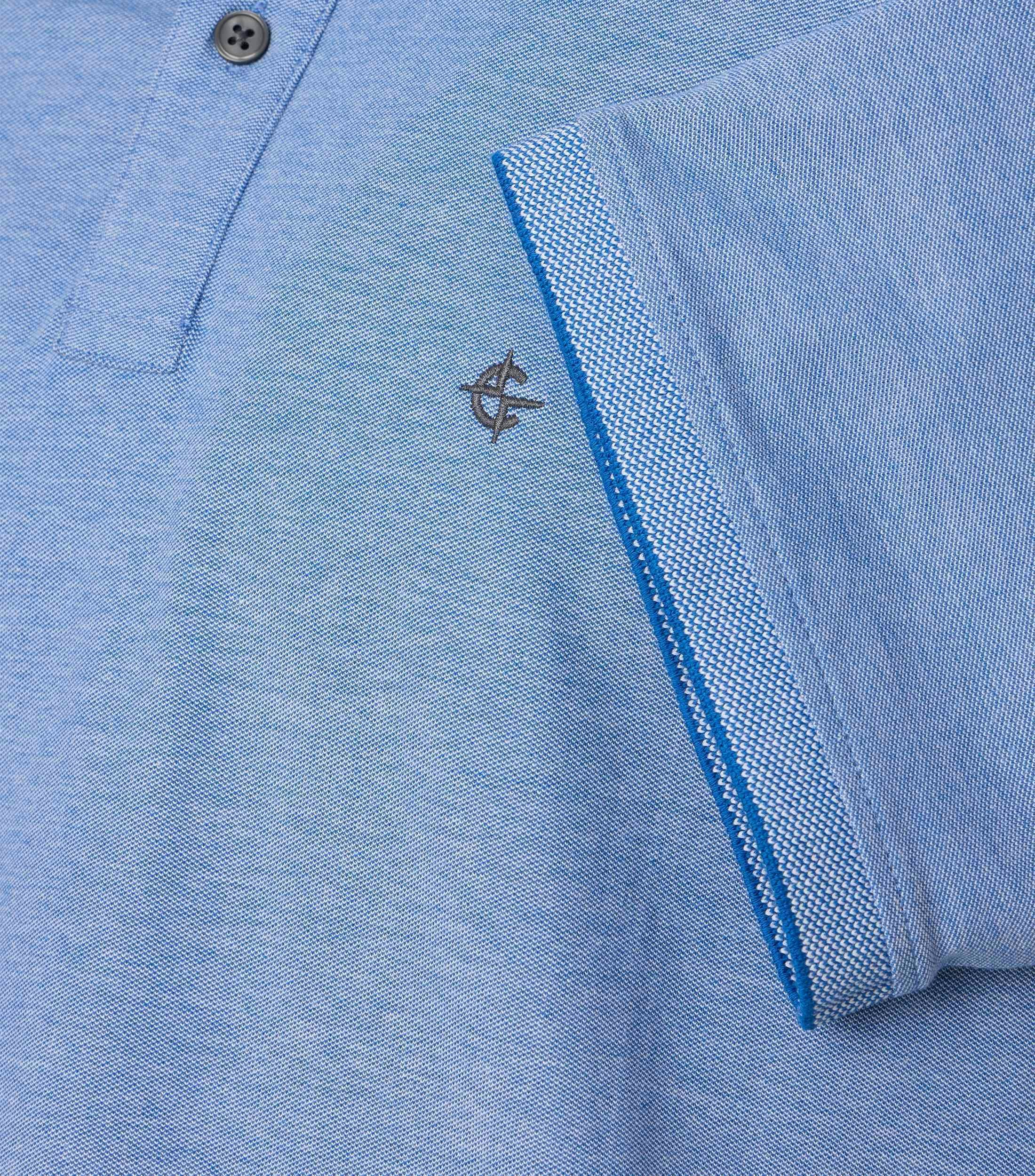 Das Model trägt ein PoloShirt im uni Muster in der Farbe Mittelblau