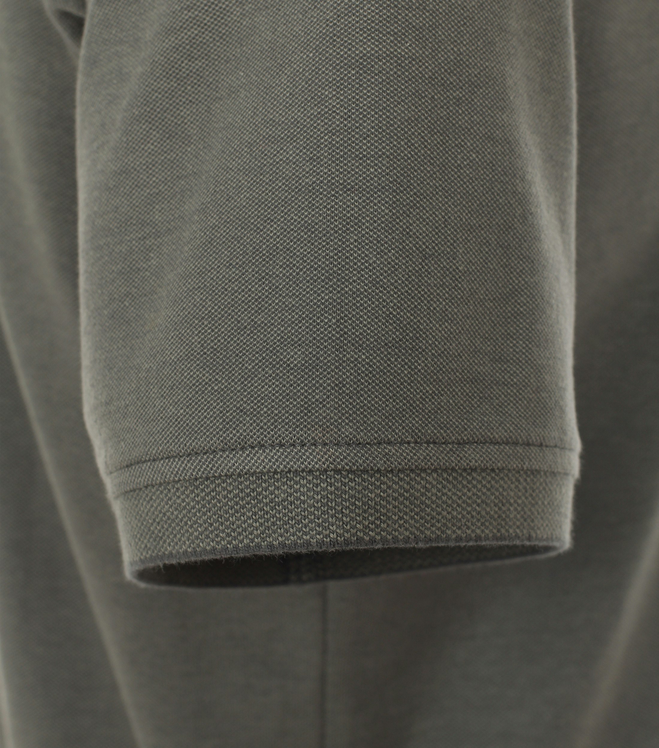 Das Model trägt ein PoloShirt im uni Muster in der Farbe Olive