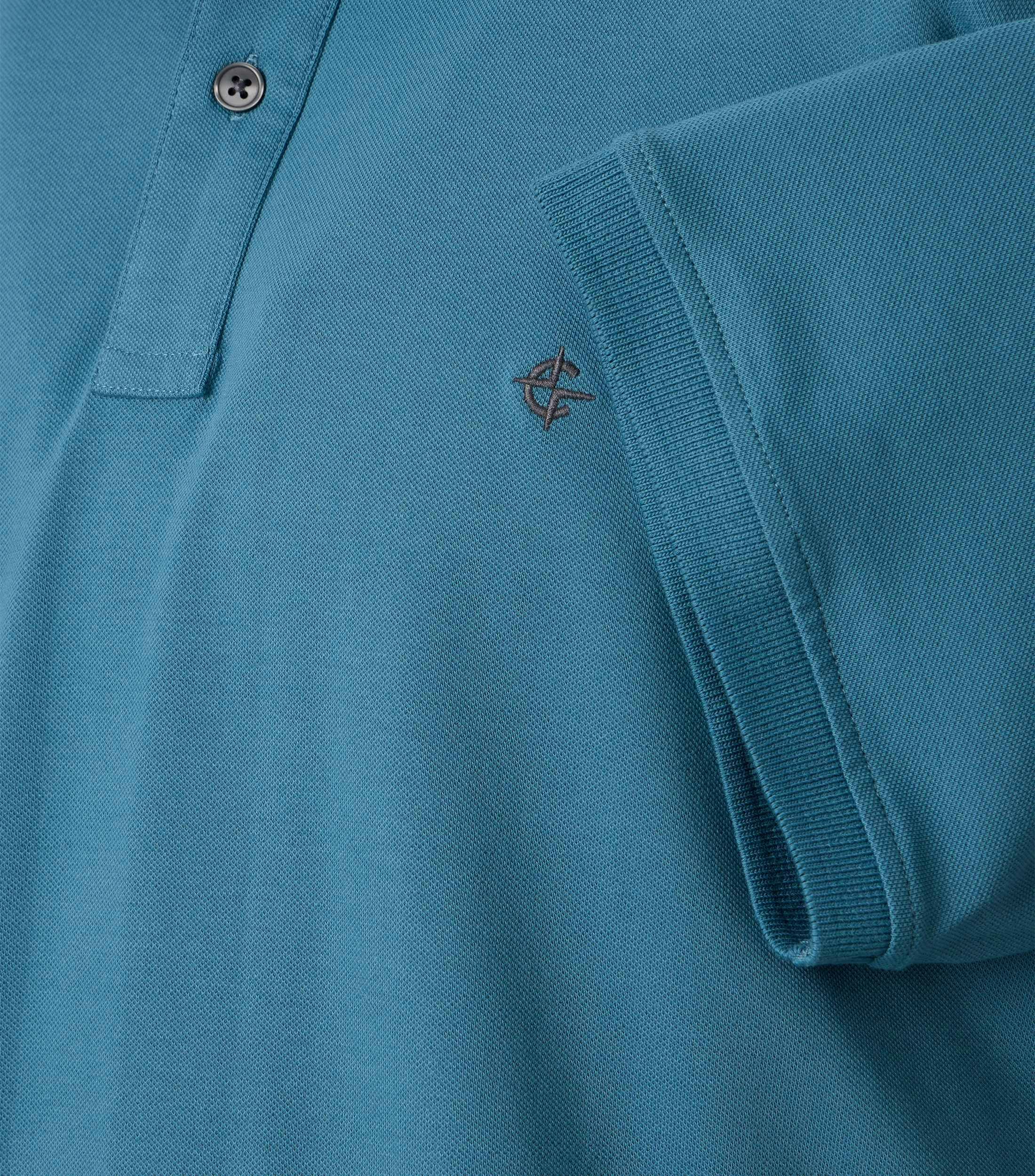 Ein Polo-Shirt im uni Muster in der Farbe dunkles Türkis