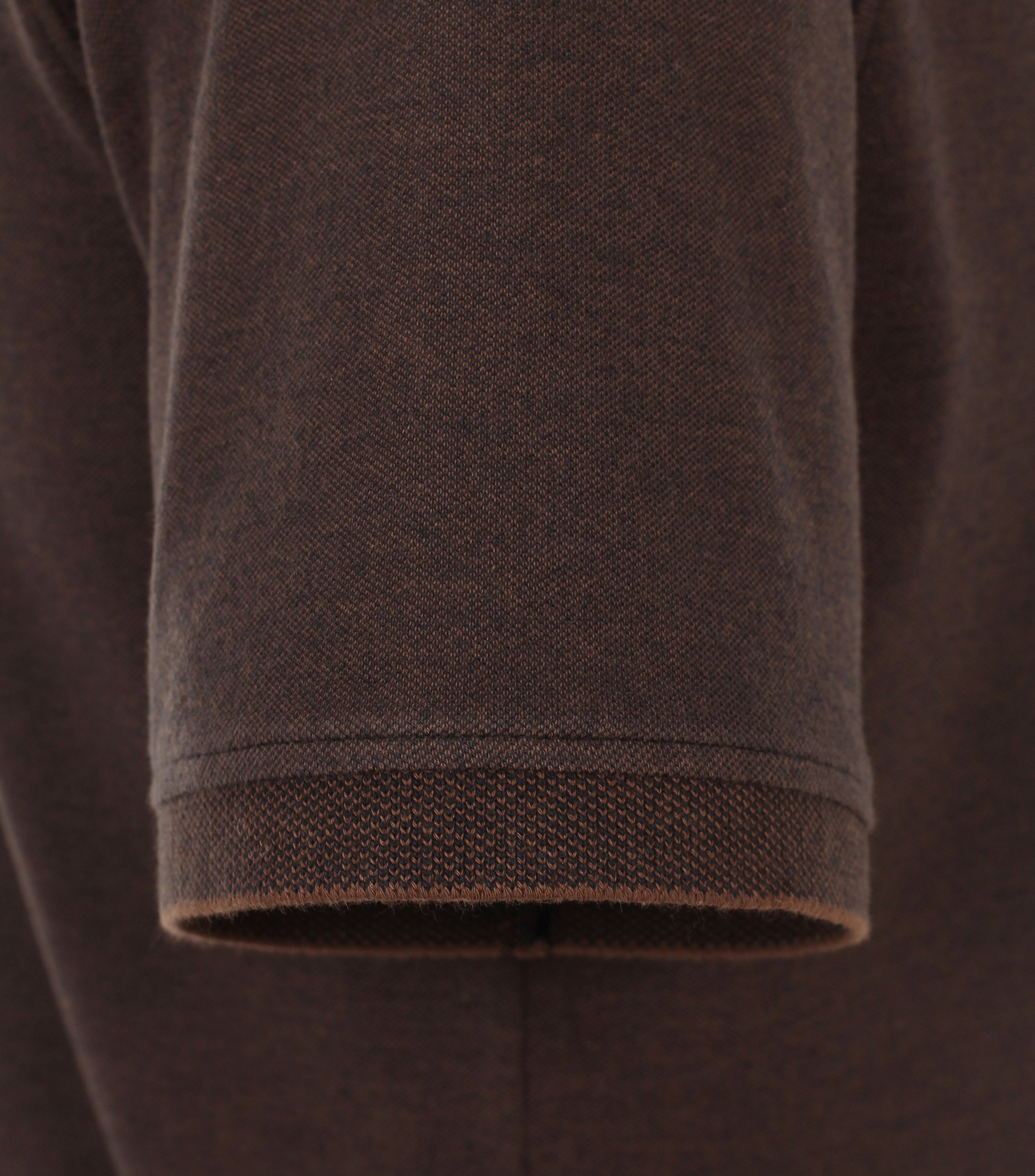 Das Model trägt ein PoloShirt im uni Muster in der Farbe Braun