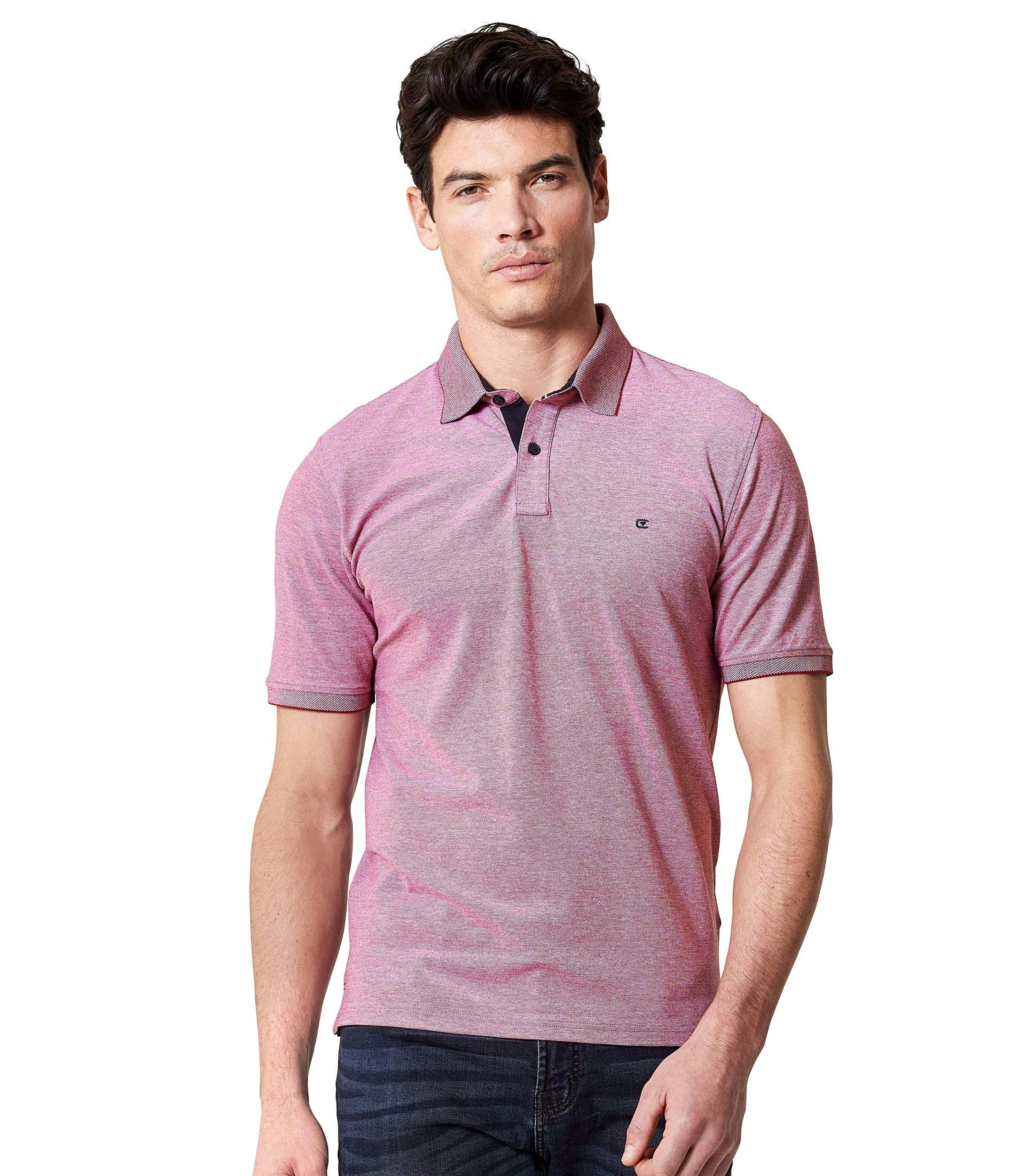 Das Model trägt ein PoloShirt im uni Muster in der Farbe Hellrot