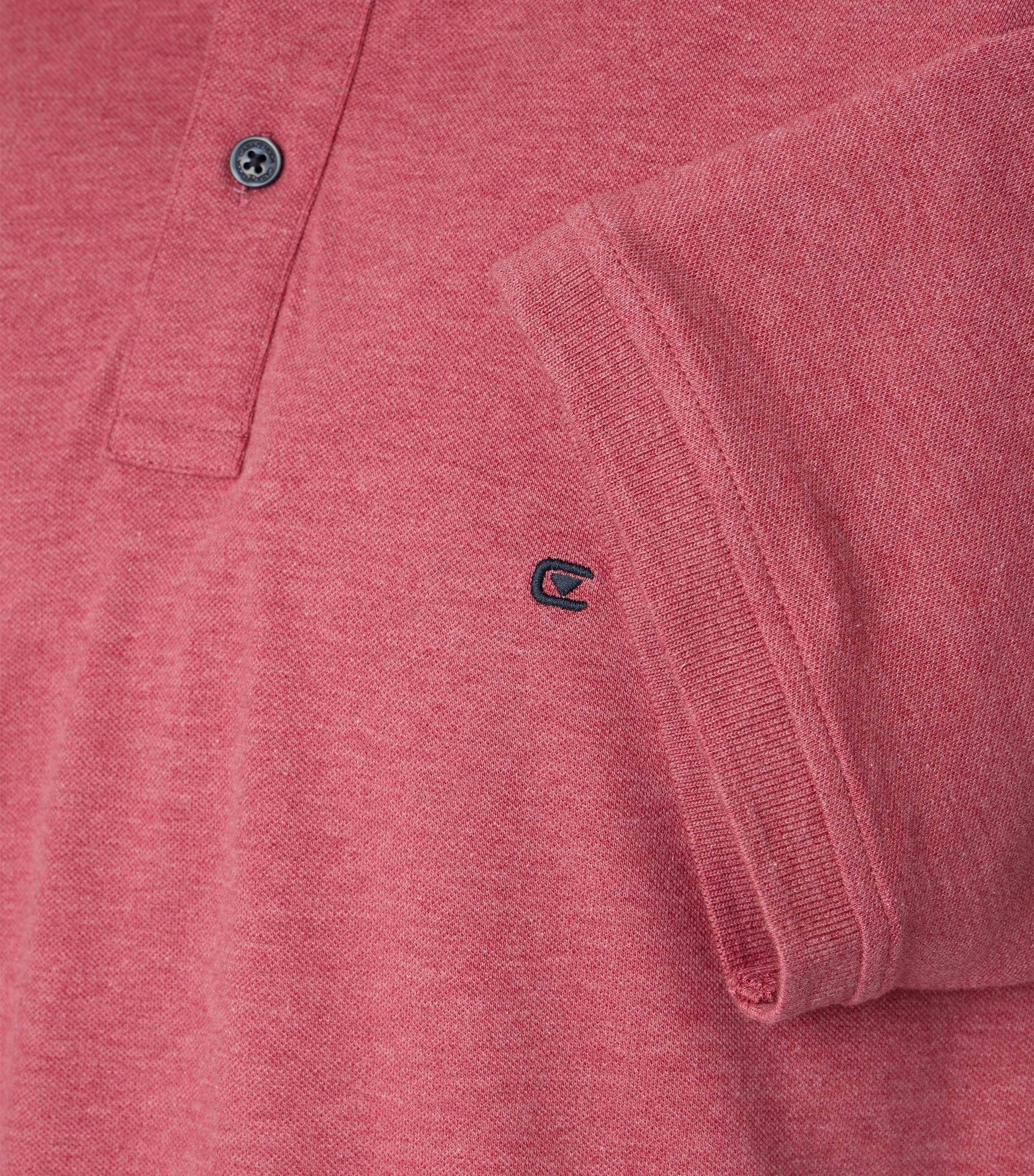 Das Model trägt ein PoloShirt im uni Muster in der Farbe Rosarot