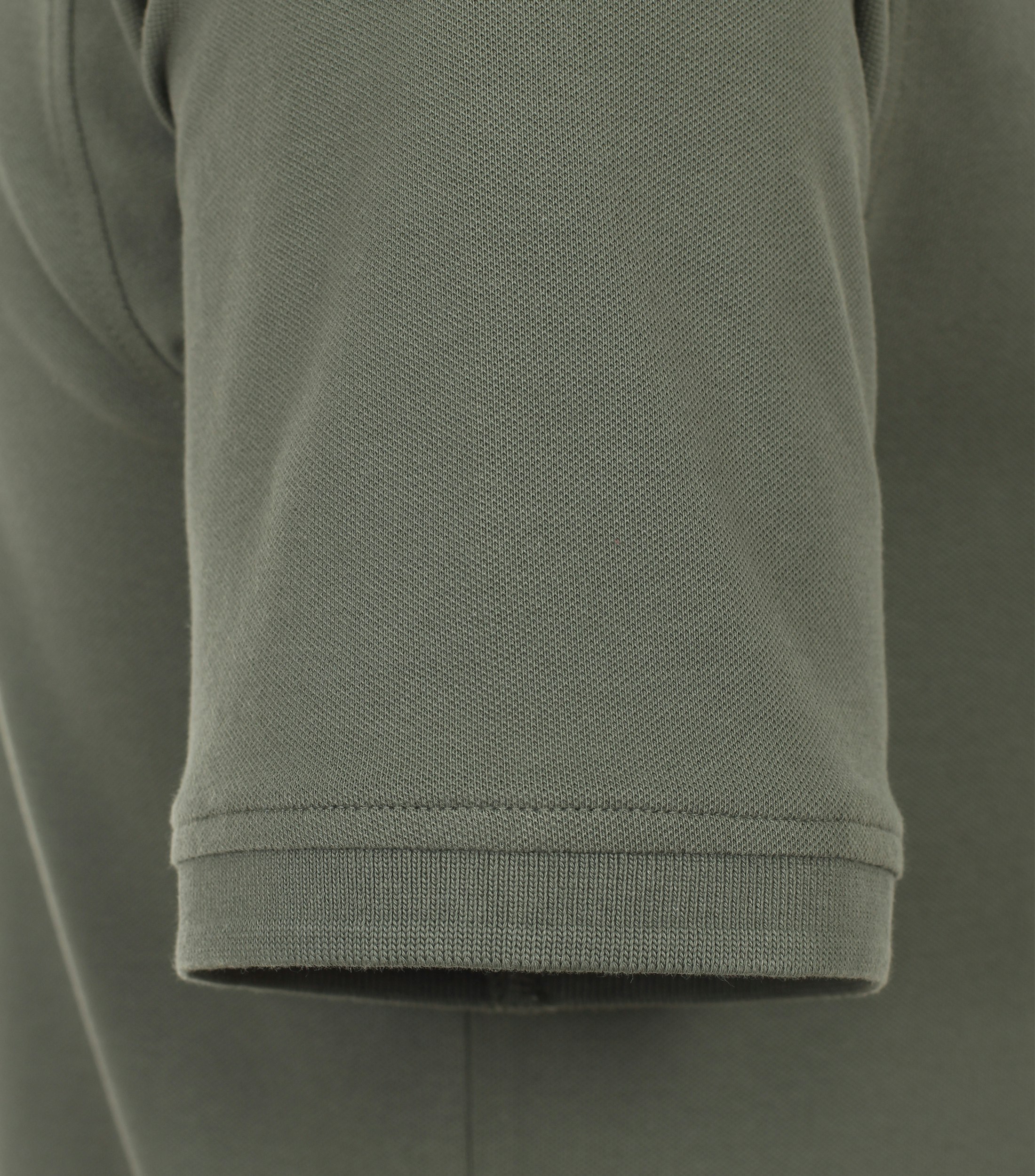 Das Model trägt ein PoloShirt im uni Muster in der Farbe Grün