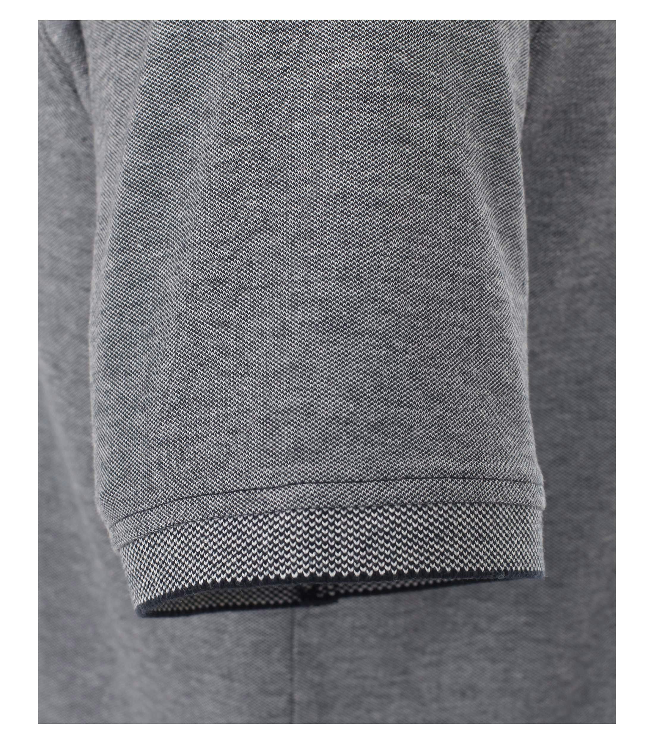 Das Model trägt ein PoloShirt im uni Muster in der Farbe Weißblau