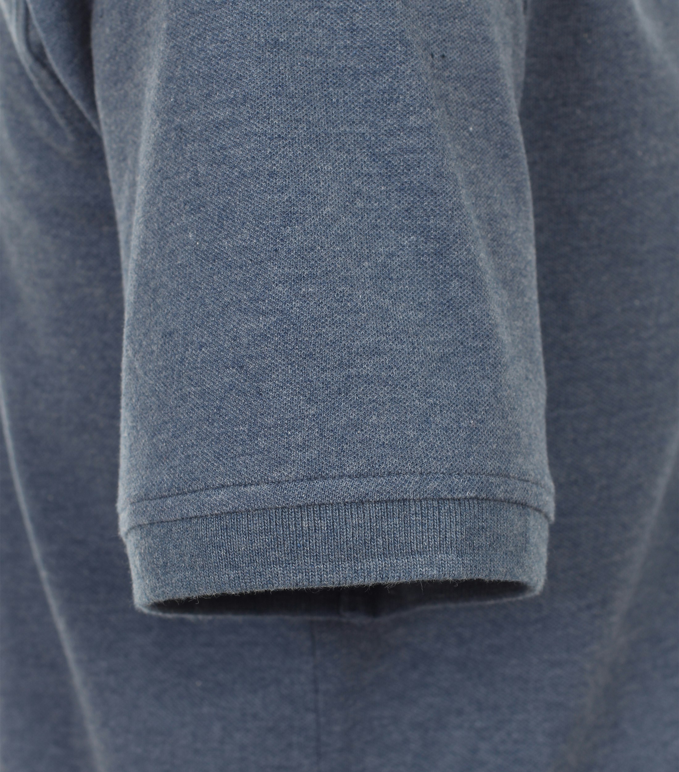 Das Model trägt ein PoloShirt im uni Muster in der Farbe dunkel Mittelblau