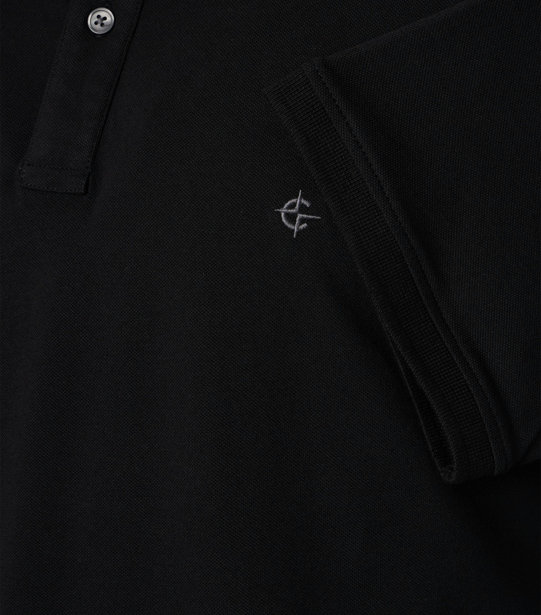 Das Model trägt ein PoloShirt im uni Muster in der Farbe Schwarz