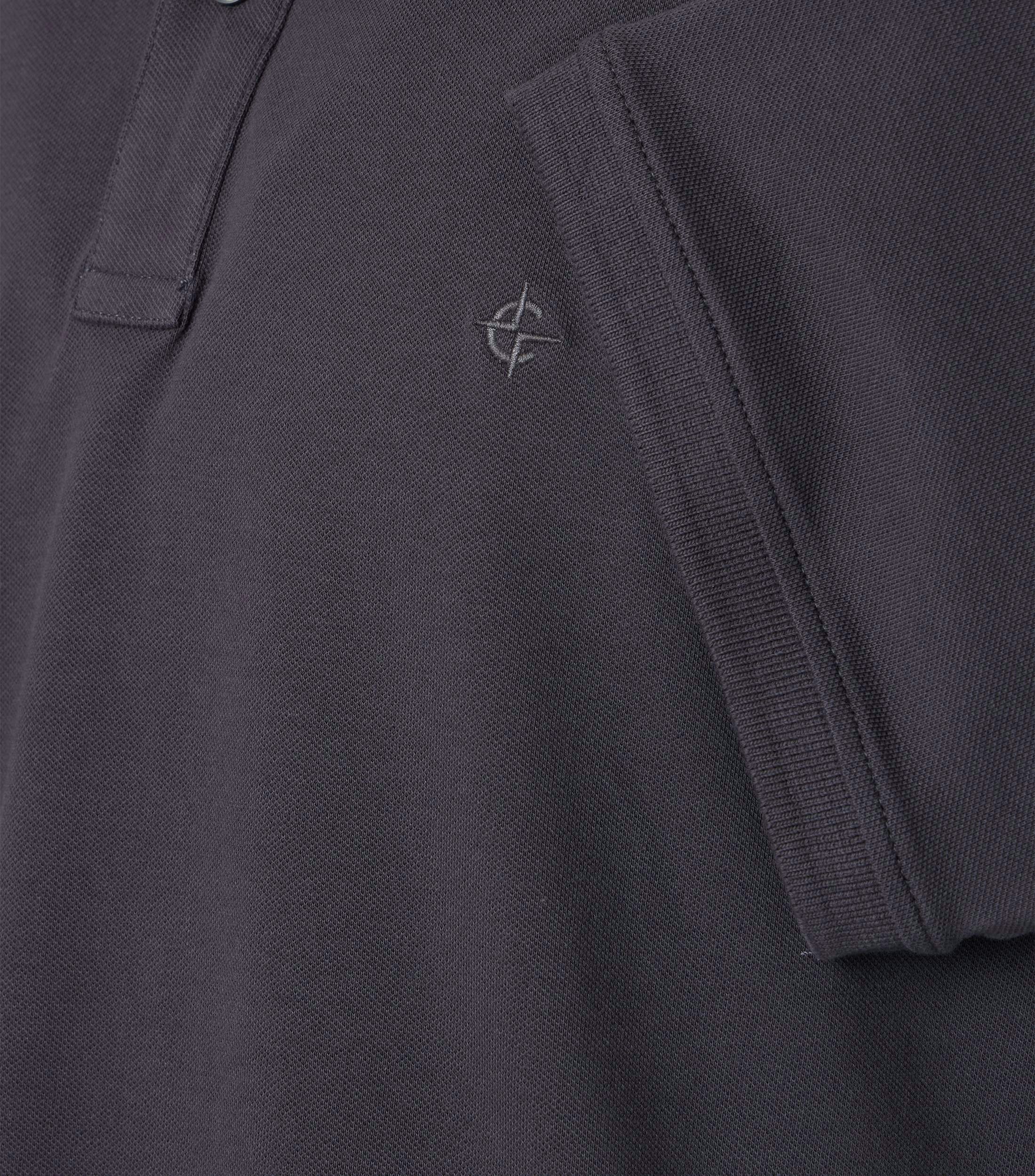 Das Model trägt ein PoloShirt im uni Muster in der Farbe Dunkelgrau