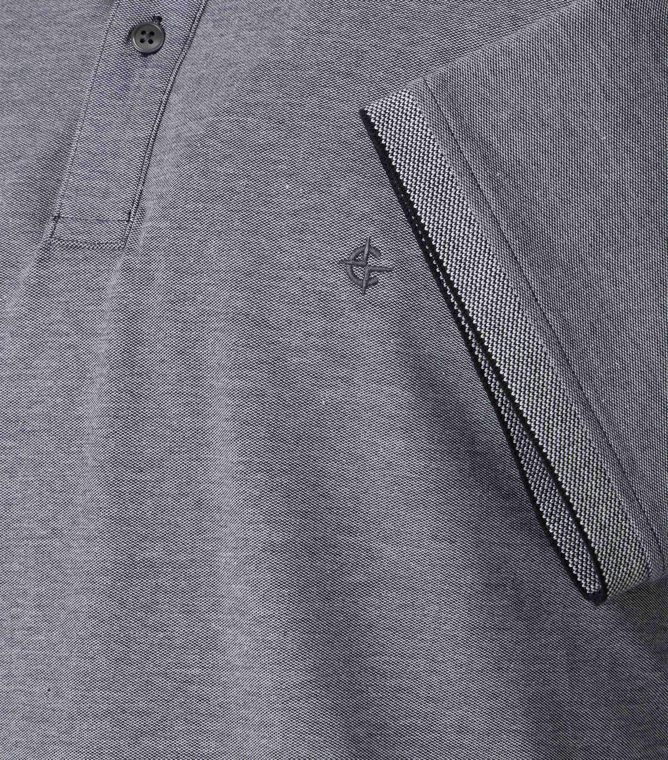 Das Model trägt ein PoloShirt im uni Muster in der Farbe Hellgrau
