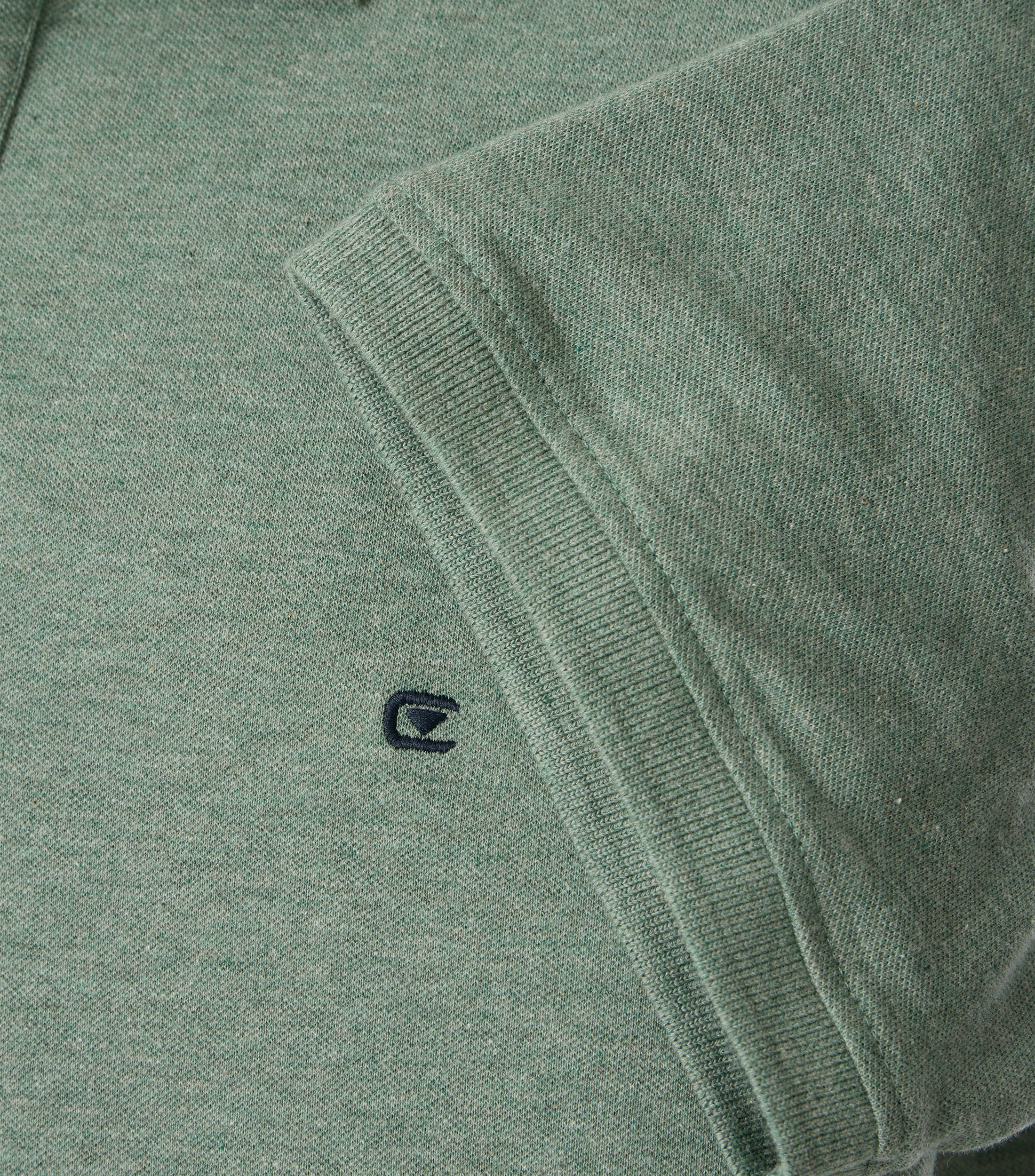 Das Model trägt ein PoloShirt im uni Muster in der Farbe  Türkisgrün