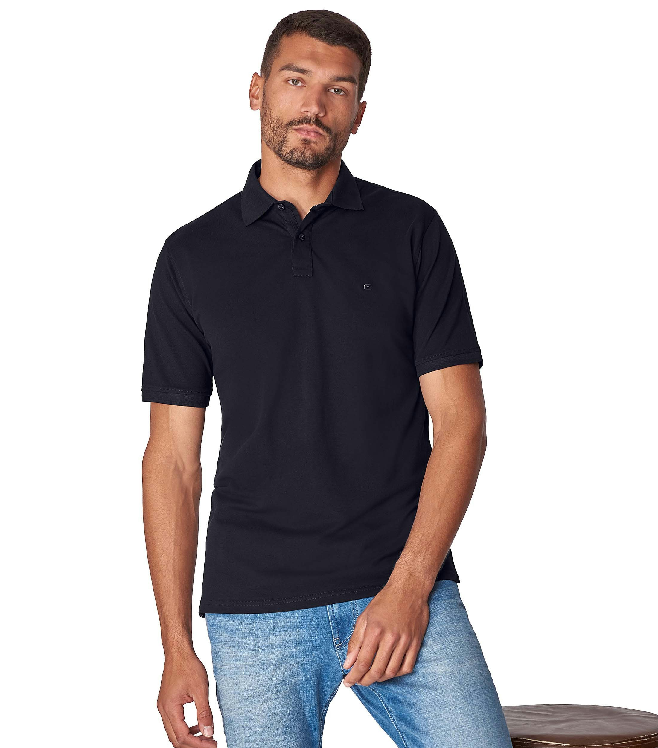 Das Model trägt ein PoloShirt im uni Muster in der Farbe Dunkelblau