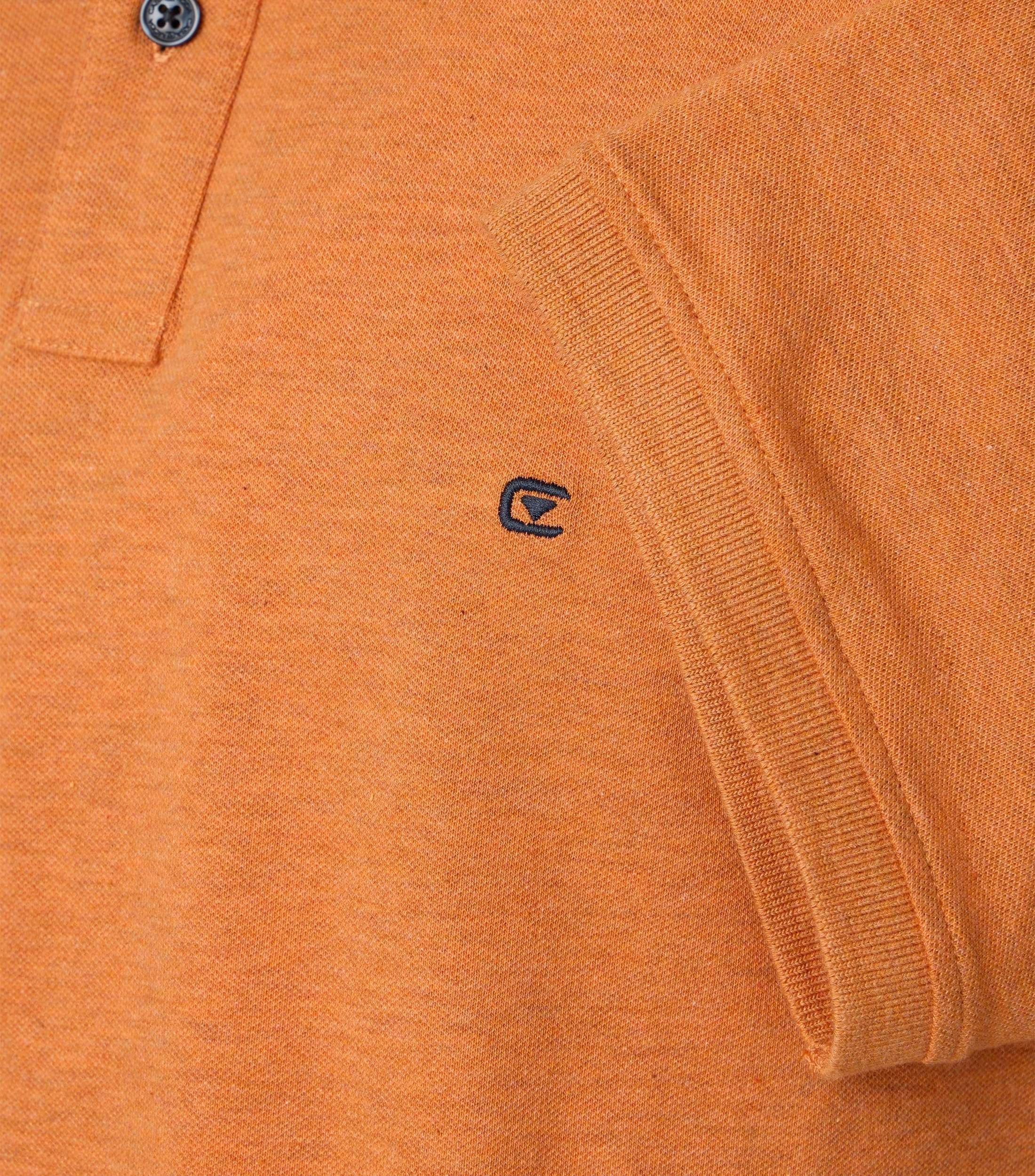 Das Model trägt ein PoloShirt im uni Muster in der Farbe Orange