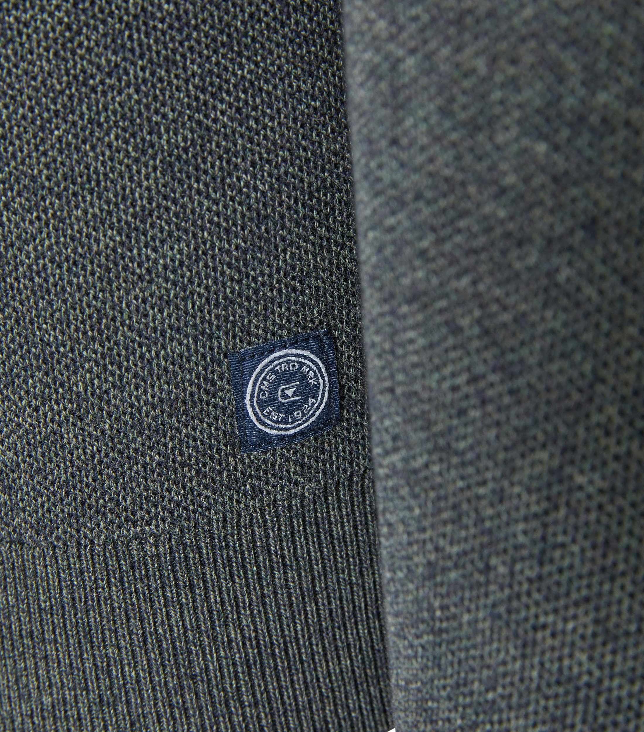 Das Model trägt ein Pullover im uni Muster in der Farbe Olive